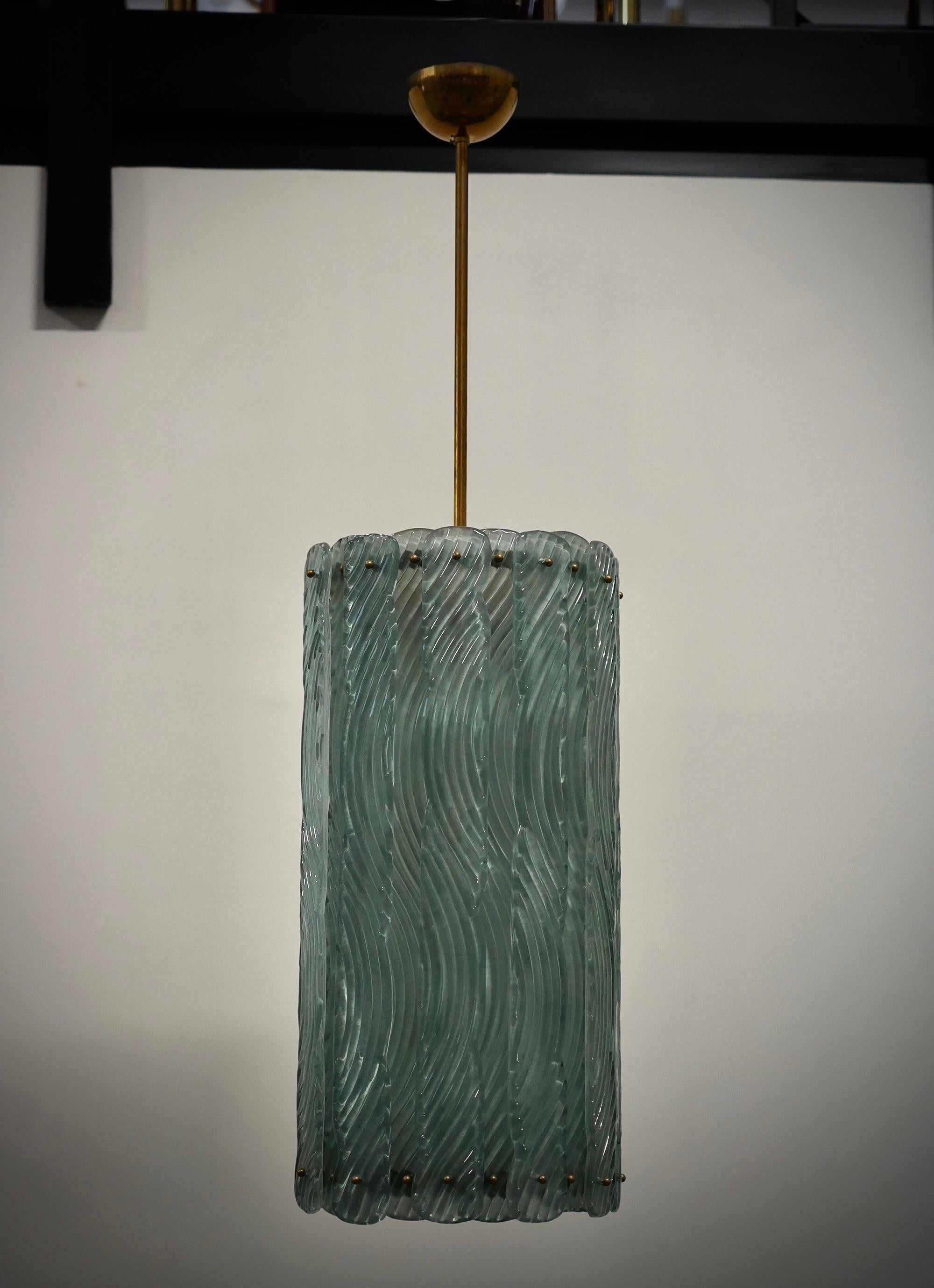 Particolare e originalissima lanterna in vetro di Murano e ottone, dal design unico arricchito da un particolare vetro con una lavorazione molto originale della fascia.

Il lampadario/lanterna ha una struttura cilindrica in ottone a cui sono state