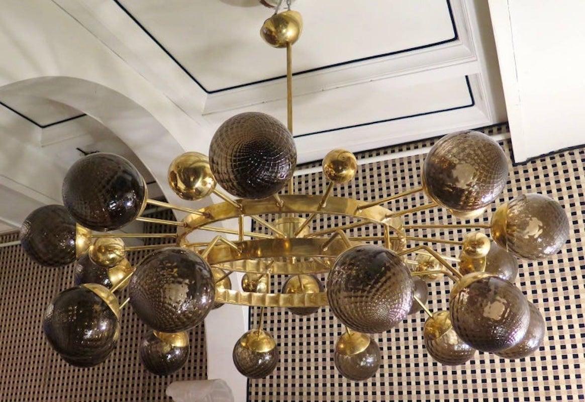 Particular circular sputnik, with brass structure and Murano glass spheres. It looks like a system of planets that gravitate circularly. A chandelier with a unique design of its kind, lots of brass and artistic glass.

Chandelier with all brass