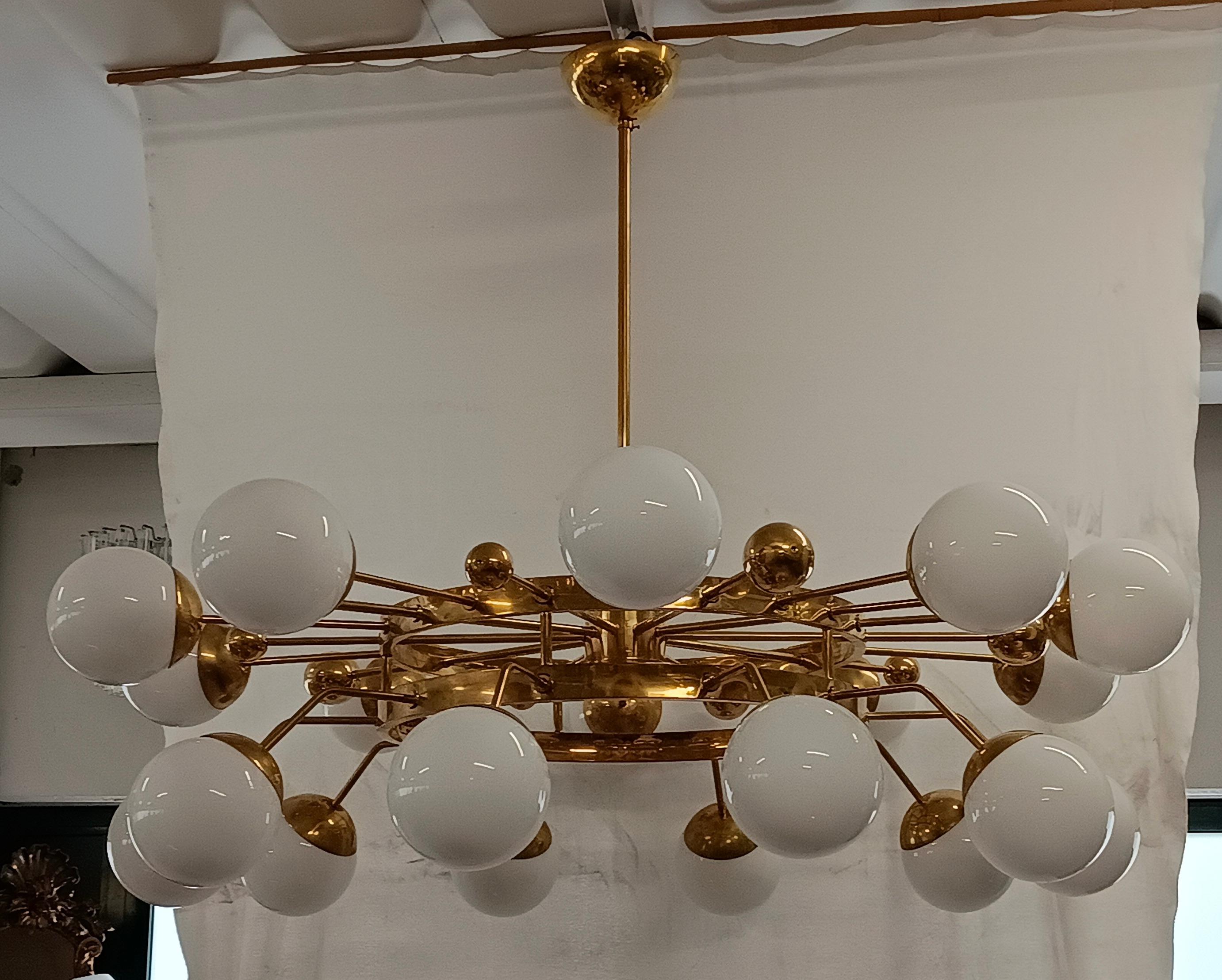 Sputnik circulaire particulier, avec structure en laiton et sphères en verre de Murano. Il ressemble à un système de planètes qui gravitent circulairement. Un lustre au design unique en son genre, avec beaucoup de laiton et du verre blanc