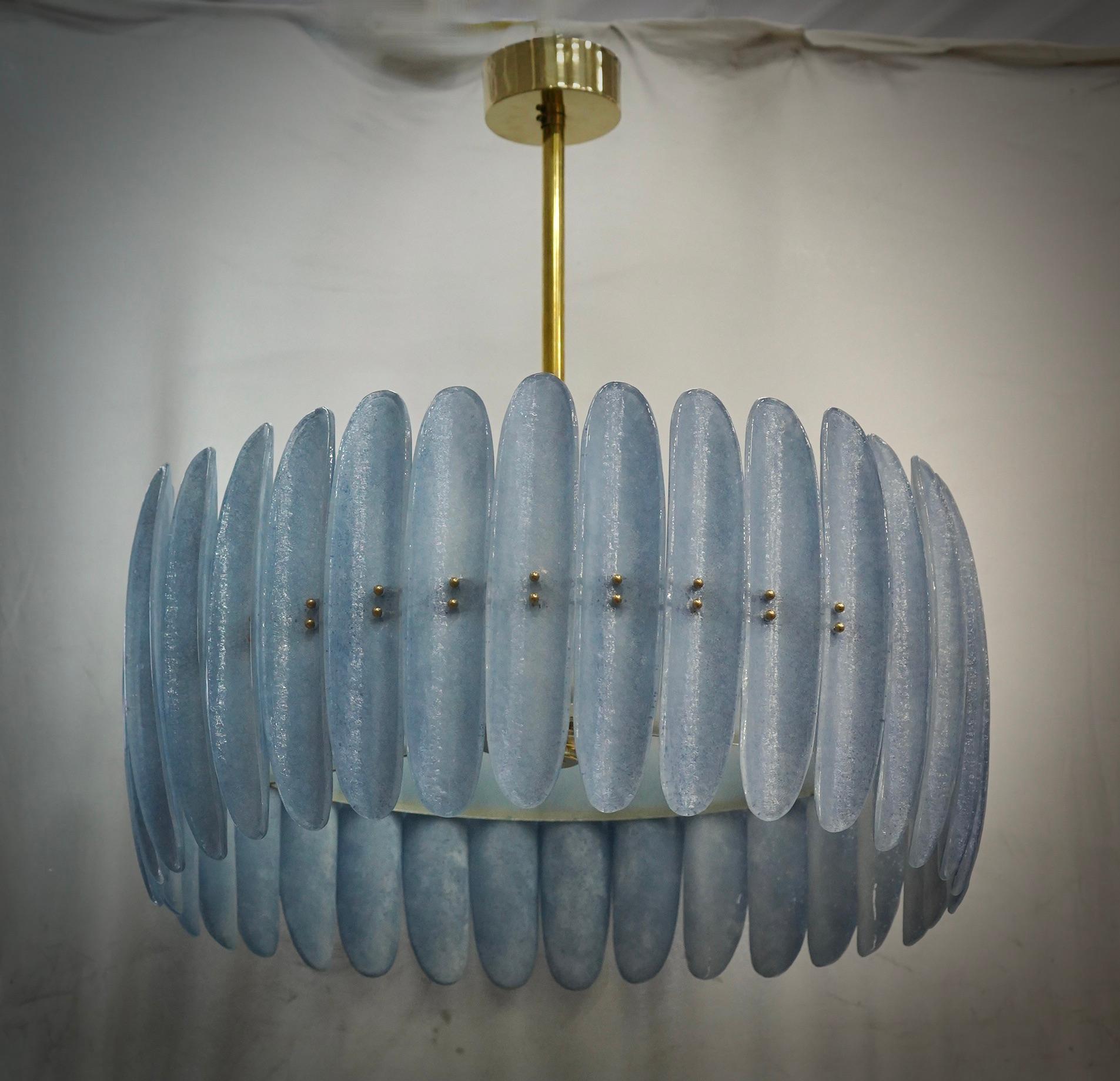 Fantastique lustre rond en verre de Murano et laiton poli. Notez la forme des demi-coquilles en verre bleu de Murano, très belle et particulière. Lustre linéaire simple mais très élégant de Murano.

Lustre Murano en verre artistique et laiton. Formé