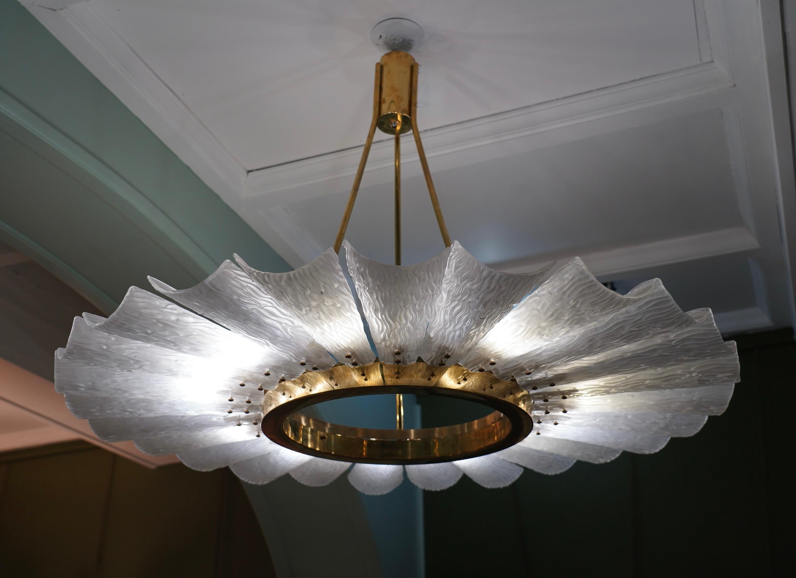 Particular circular chandelier, with brass structure and Murano glass tiles. It looks like a system of planets gravitating circularly. A chandelier with a one-of-a-kind design, lots of brass and sandblasted artistic glass.

The chandelier with an
