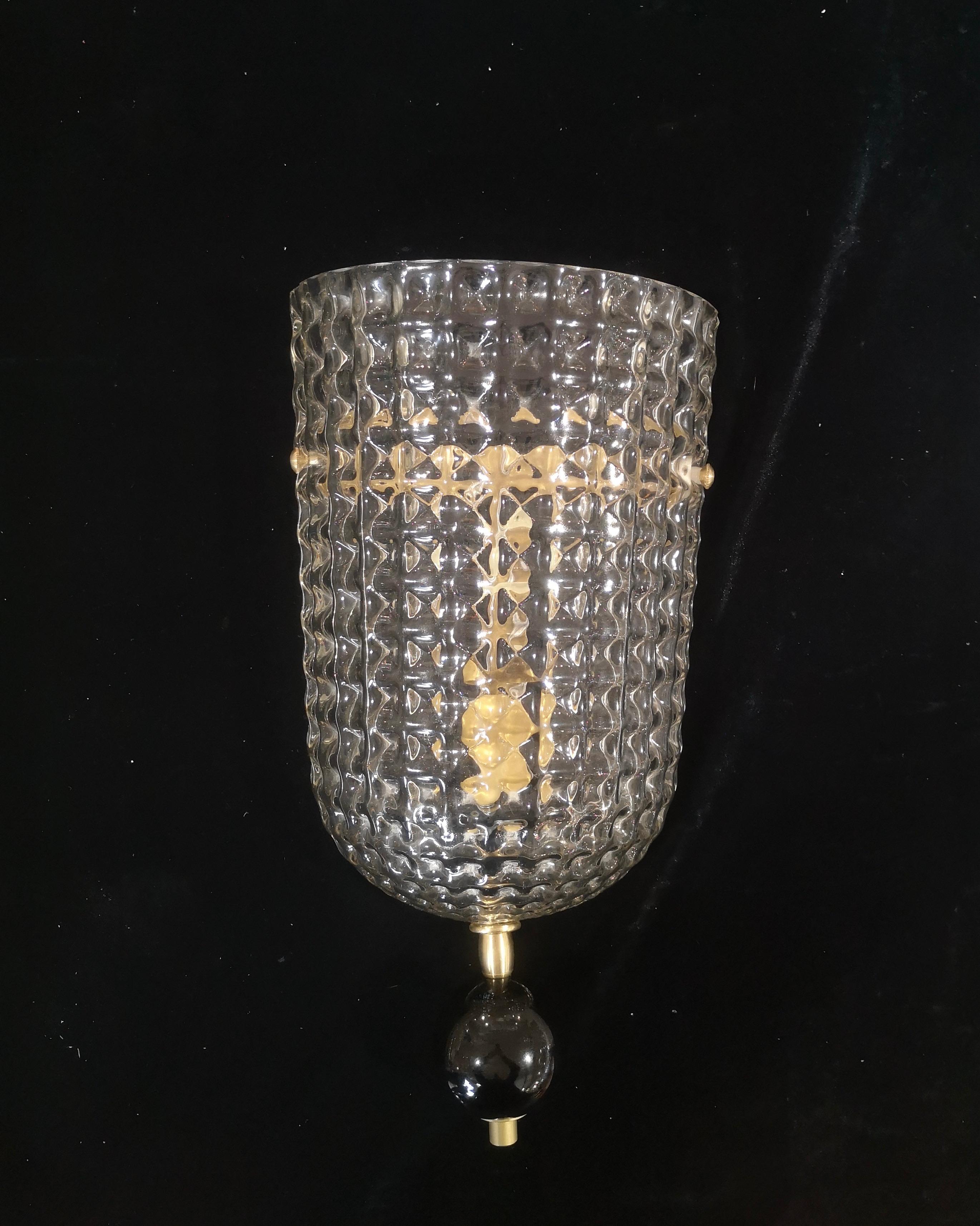 Diseño refinado y delicado para este aplique con cristal de Murano transparente y de color negro. Los hornos de Murano crean un indiscutible diseño atemporal, sencillo pero elegante al mismo tiempo.

El aplique está formado por una estructura