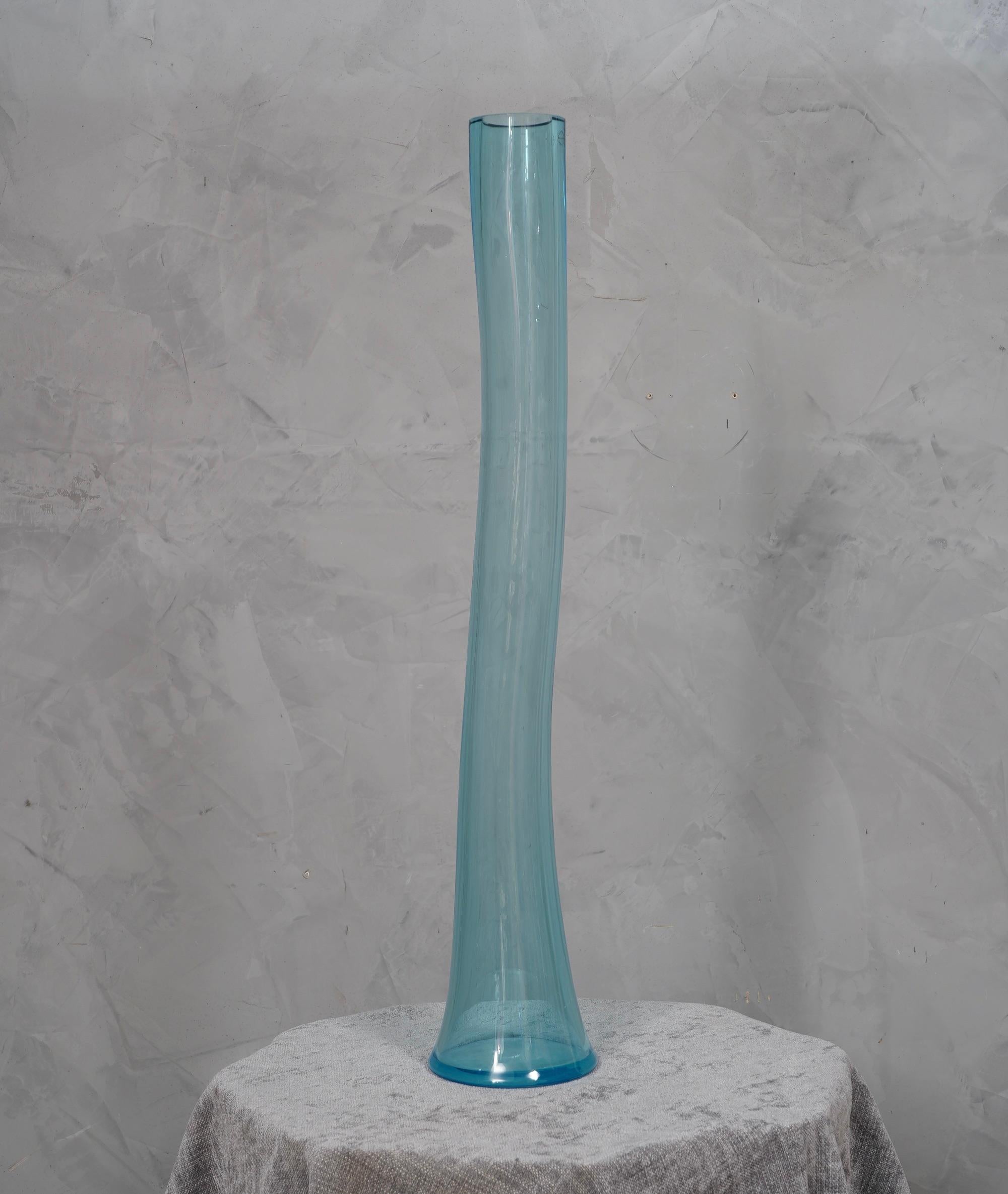 Précieux et unique vase en verre de Murano soufflé à la main, de couleur bleu clair, au design classique mais original et à la forte épaisseur du verre. Vase linéaire et stylisé.

Le vase a une forme cylindrique longue et étroite, avec une base