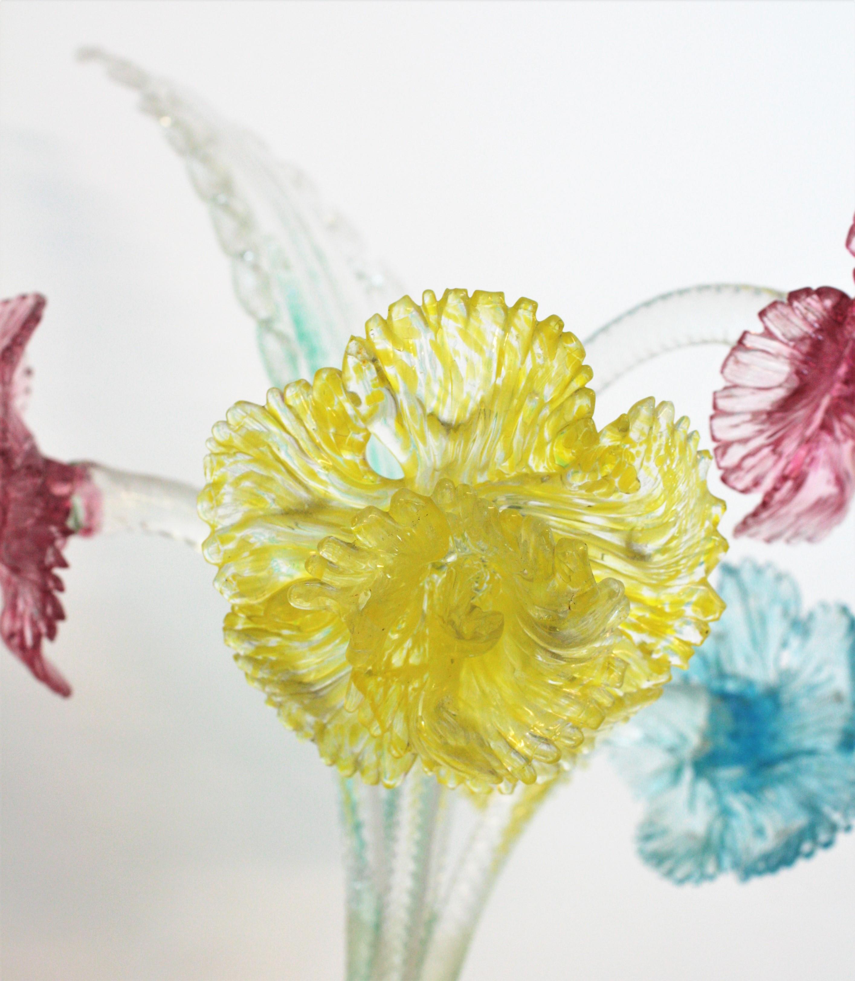 Outstanding Large Bouquet of Murano Blown Glass Flowers. Italy, 1920s.
This colorful set is comprised by 5 long stem flowers in yellow, pink and blue and one large leave. The stems are made in clear glass with swirl ribbon details.
Place them in a