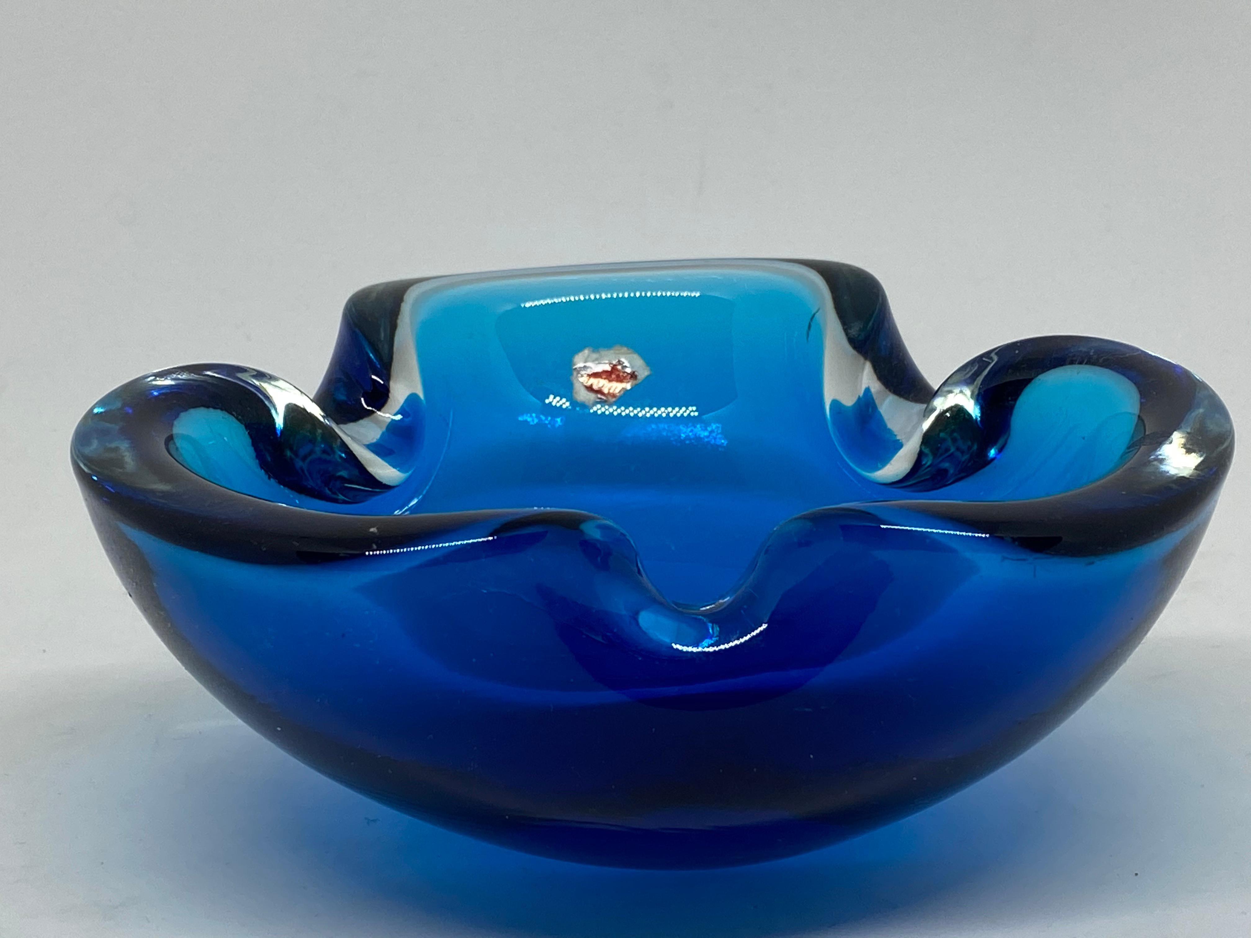 Gorgeous hand blown Murano art glass piece with Sommerso and bullicante techniques. A beautiful organic shaped bowl, catchall or ashtray in blue and clear, Italy, 1970s.