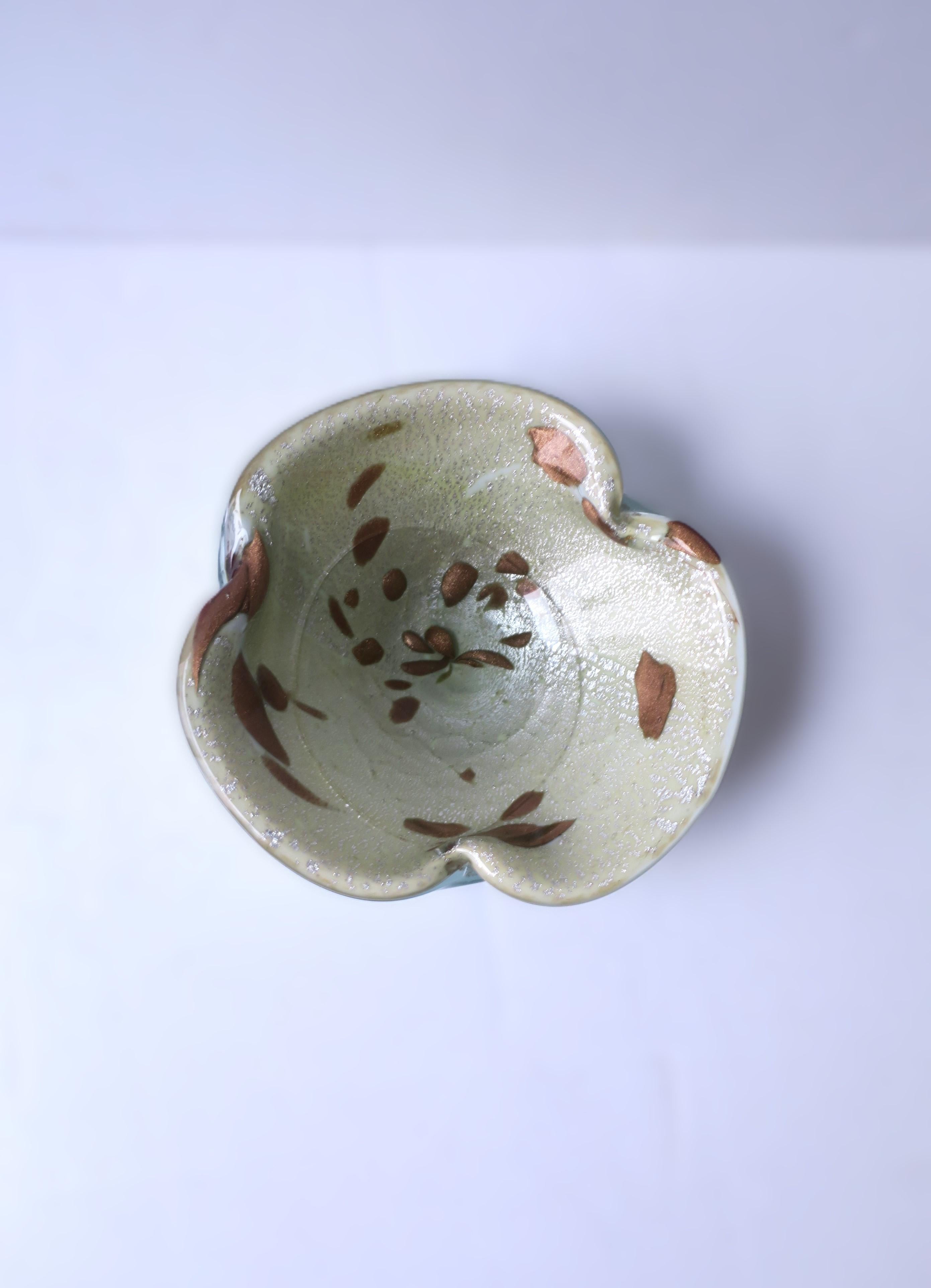A beautiful and substantial Italian Murano light green art glass bowl, Midcentury Modern period, attributed to designer Alfredo Barbini, circa mid-20th century, Italy. Murano art glass colors include a white underside, a very light green base with