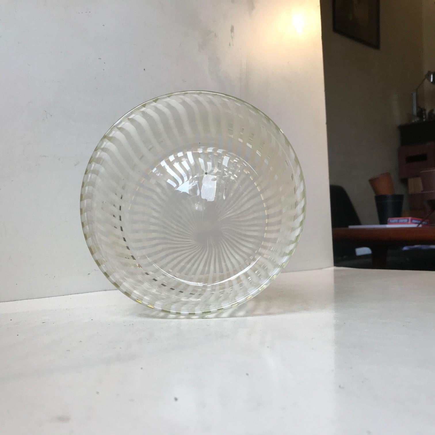 Circular clear glass bowl decorated with white incapsulated glass stripes. Technique: (Italian) Canne/Canne Retorte. It was made by Venini in Murano Italy during the 1960s and was probably designed by Fulvio Bianconi. Measurements: D: 16.5, H: 10.5