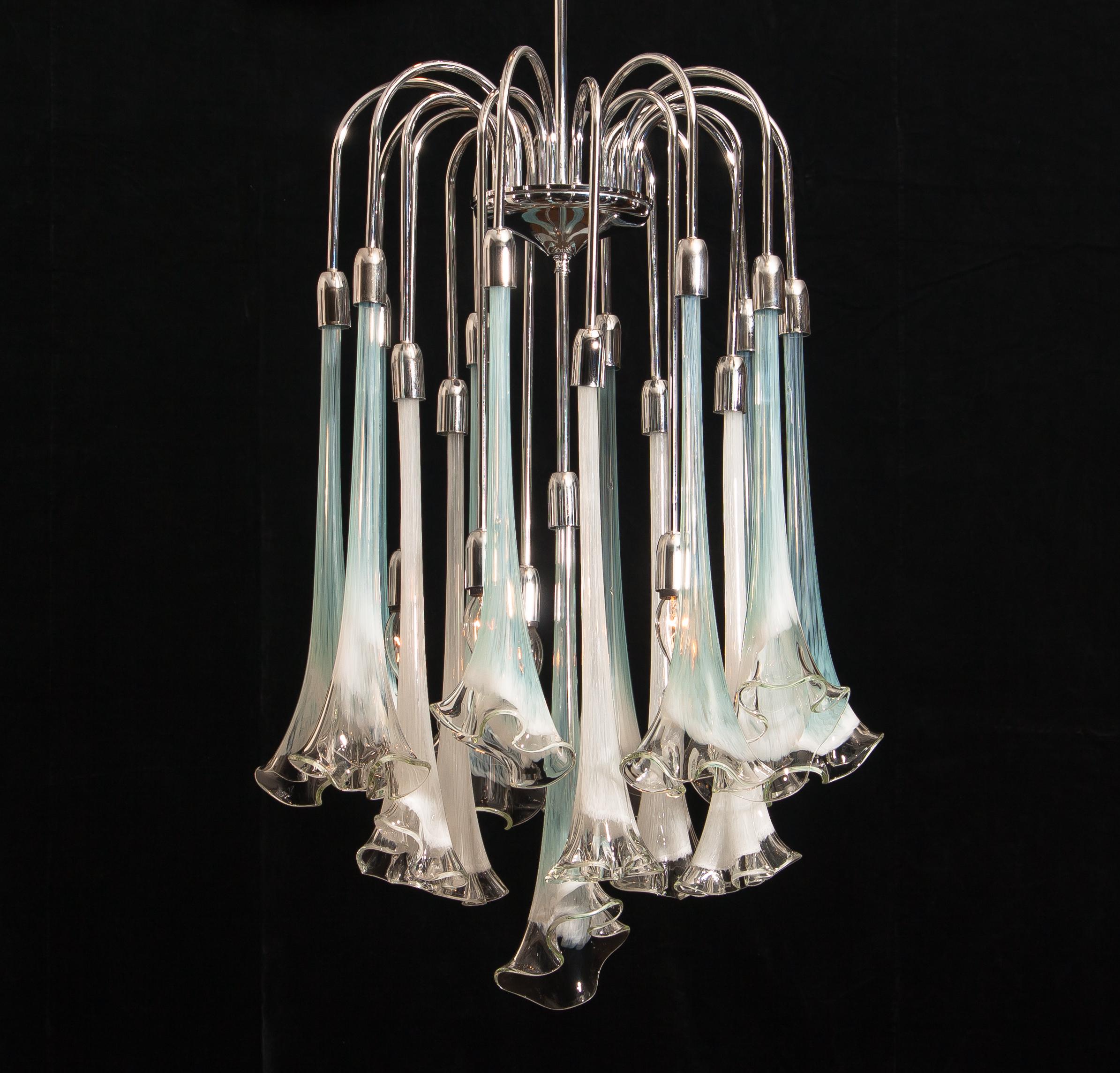 Extremely beautiful and rare Mazzega chandelier filled with Murano art glass.
The sixteen large white and turquoise glass flowers are all in excellent condition.
Also the chrome fixture is perfect. Technically 100%.
The chandelier has five E14 /