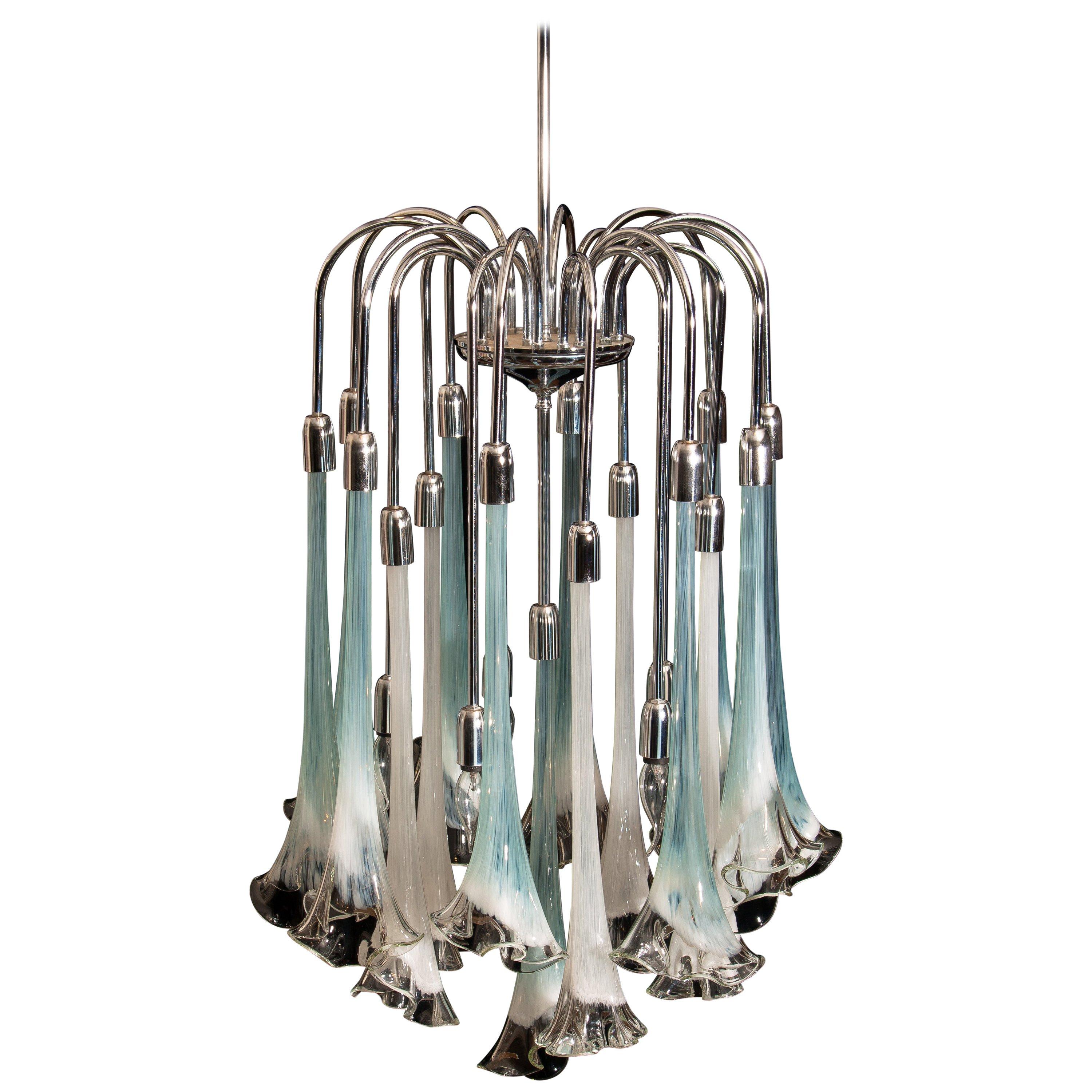 Extremely beautiful and rare Mazzega chandelier filled with Murano art glass.
The 16 large white and turquoise glass flowers are all in excellent condition.
Also, the chrome fixture is perfect. Technically 100%.
The chandelier has five E14 / E17
