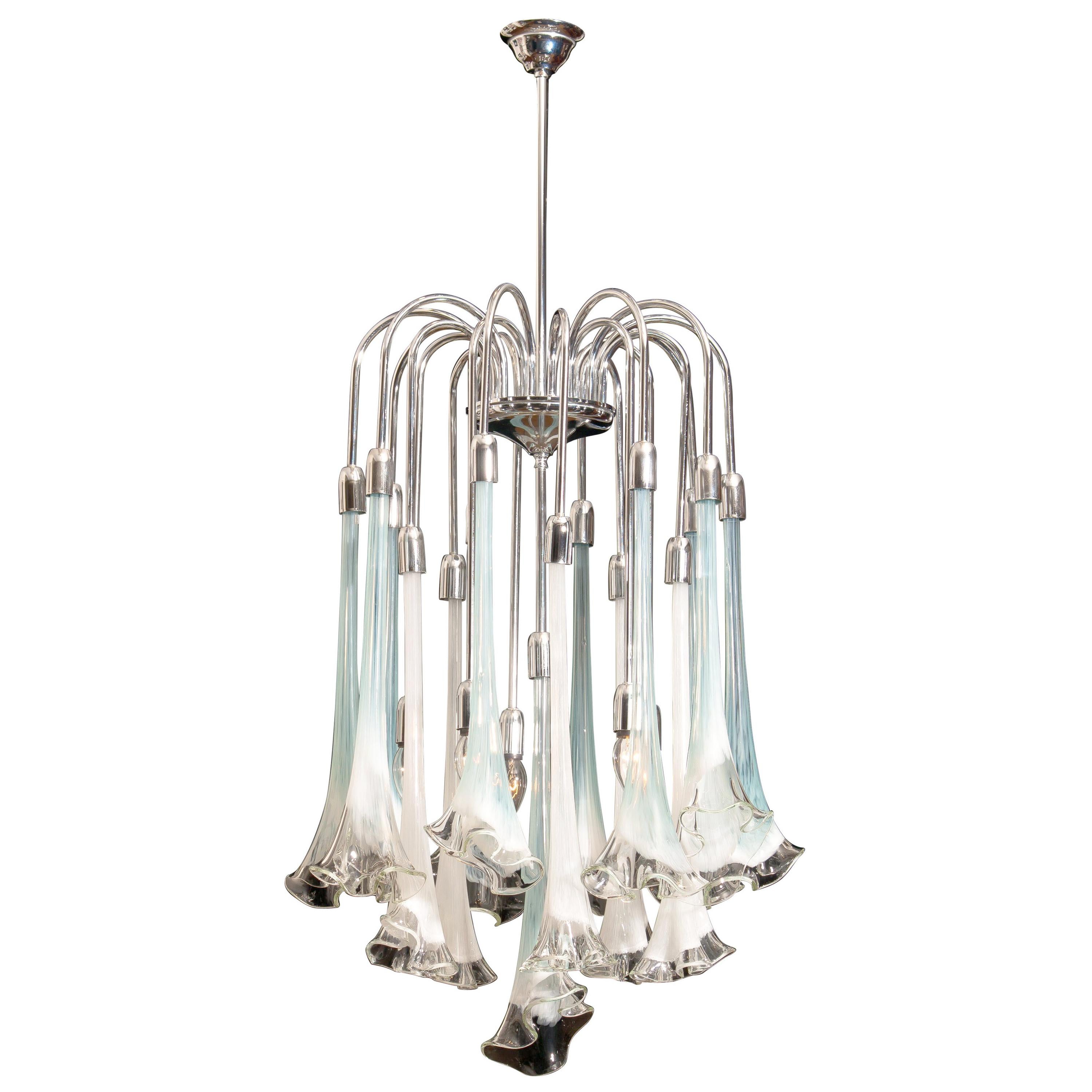 Extremely beautiful and rare Mazzega chandelier filled with Murano art glass.
The 16 large white and turquoise glass flowers are all in excellent condition.
Also, the chrome fixture is perfect. Technically 100%.
The chandelier has five E14 / E17