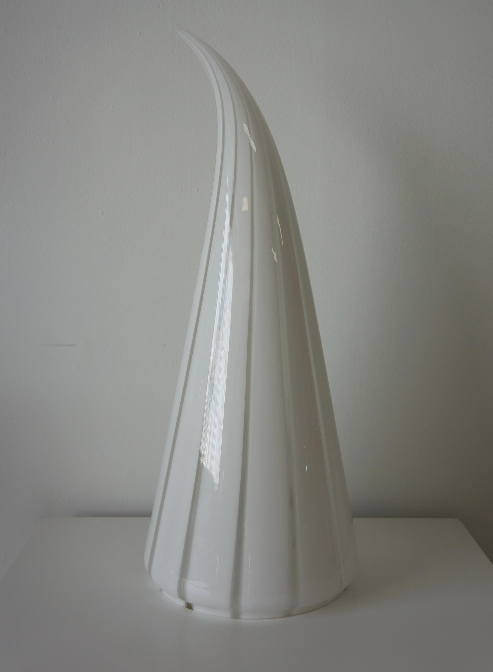 Spectaculaire lampe de forme conique en verre de Murano qui s'arrondit au sommet. Dans le style de Venini et fabriqué dans les années 1970 à Murano. Il est rayé de verre d'art clair et blanc laiteux. C'est une belle lampe qui diffuse une lumière