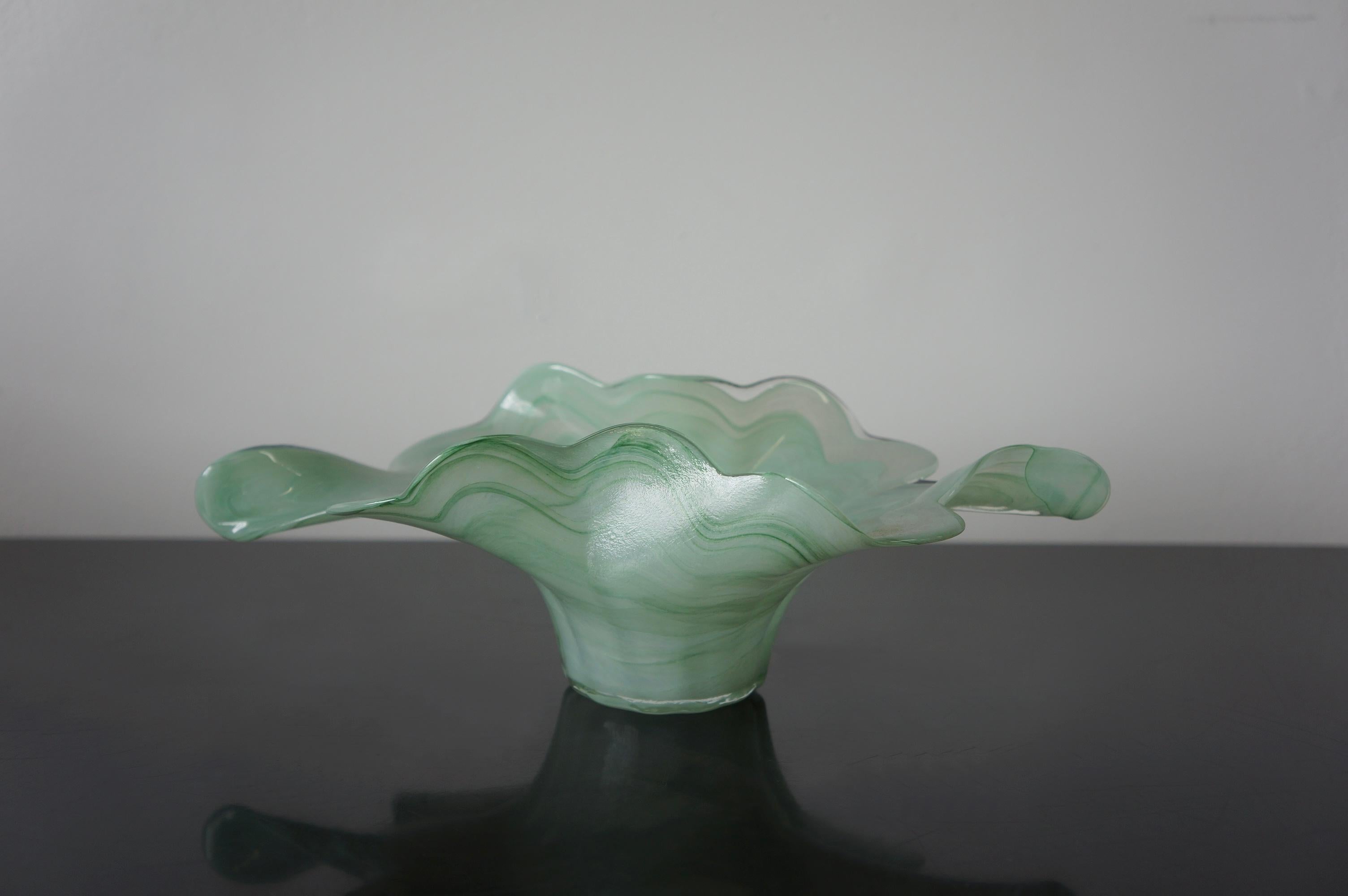 Unique Silvestri Arte Murano ribbon bowl in green swirled Art glass. It was made in Murano, Italy. This free form shaped is made with light green and clear swirled Art glass. The translucent green glass is intertwined with clear glass to give a