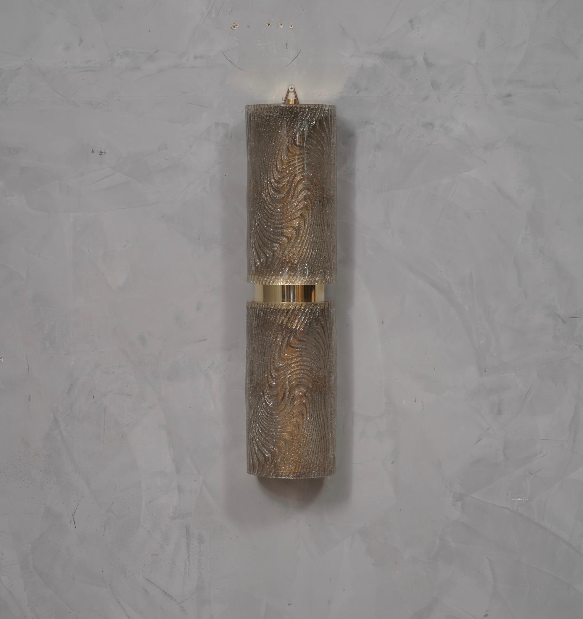 Refined and delicate design for this wall light with dove-gray color Murano glass.

The applique is formed by a metal structure gold colored that allows the superimposed housing of two beautiful dove gray Murano glass tiles. The design is very clean