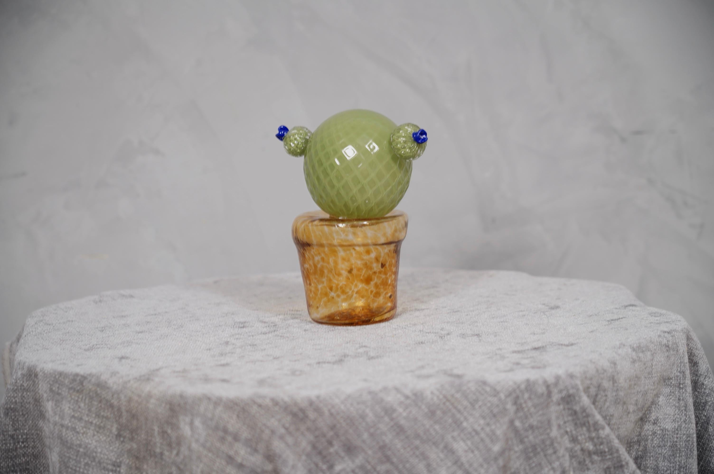 Italian design, this cactus is a fashion icon of the Italian style, green with a beautiful amber glass vase underneath. The Murano furnaces create an indisputable timeless design, simple but elegant at the same time. Refinement and class, typical of