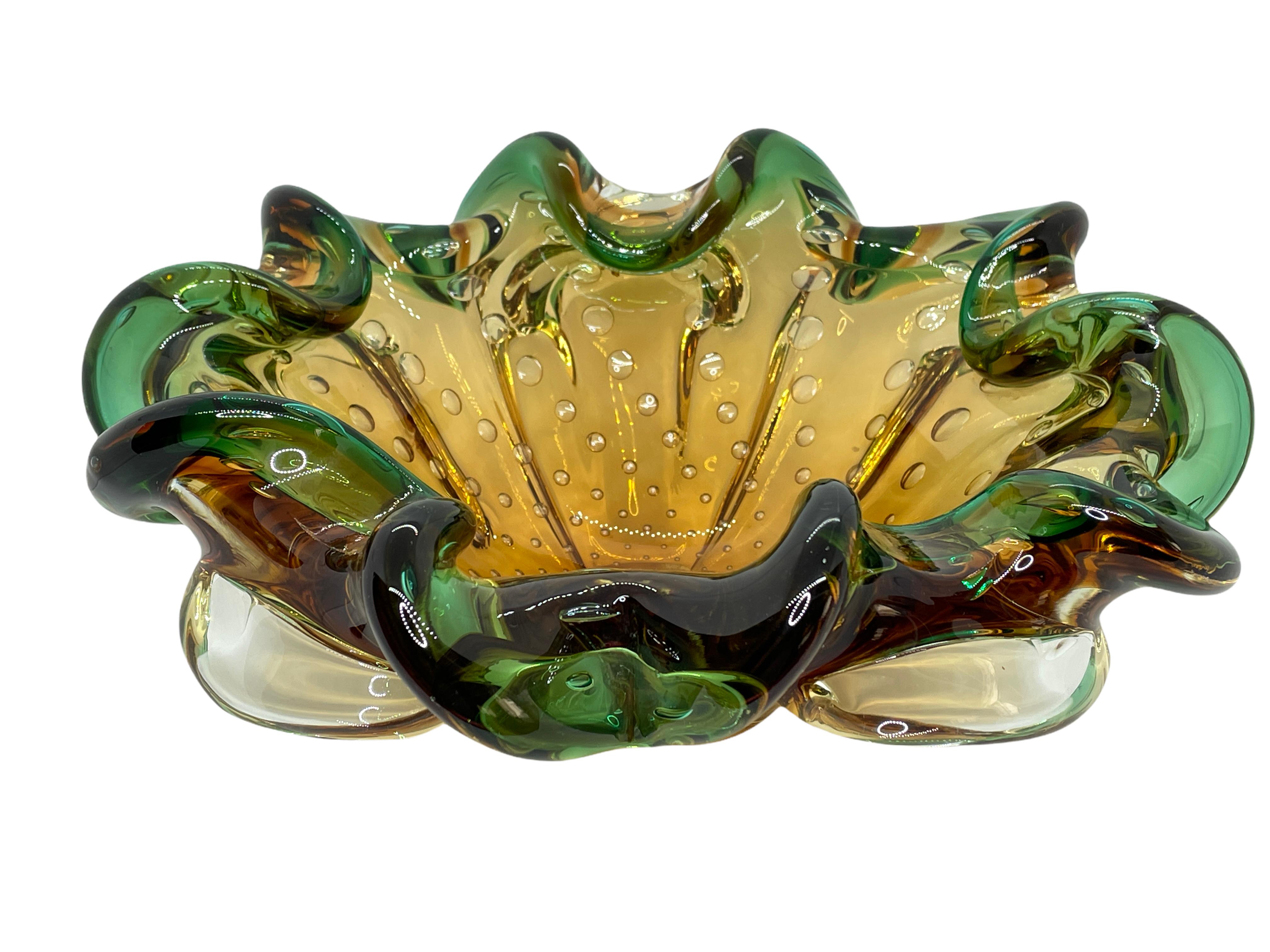An amazing Venetian Murano glass object in an unusual design and a pretty beautiful green and amber color. A highly decorative piece useful as center piece, bowl, fruit bowl or catchall. Italy, 1970s.