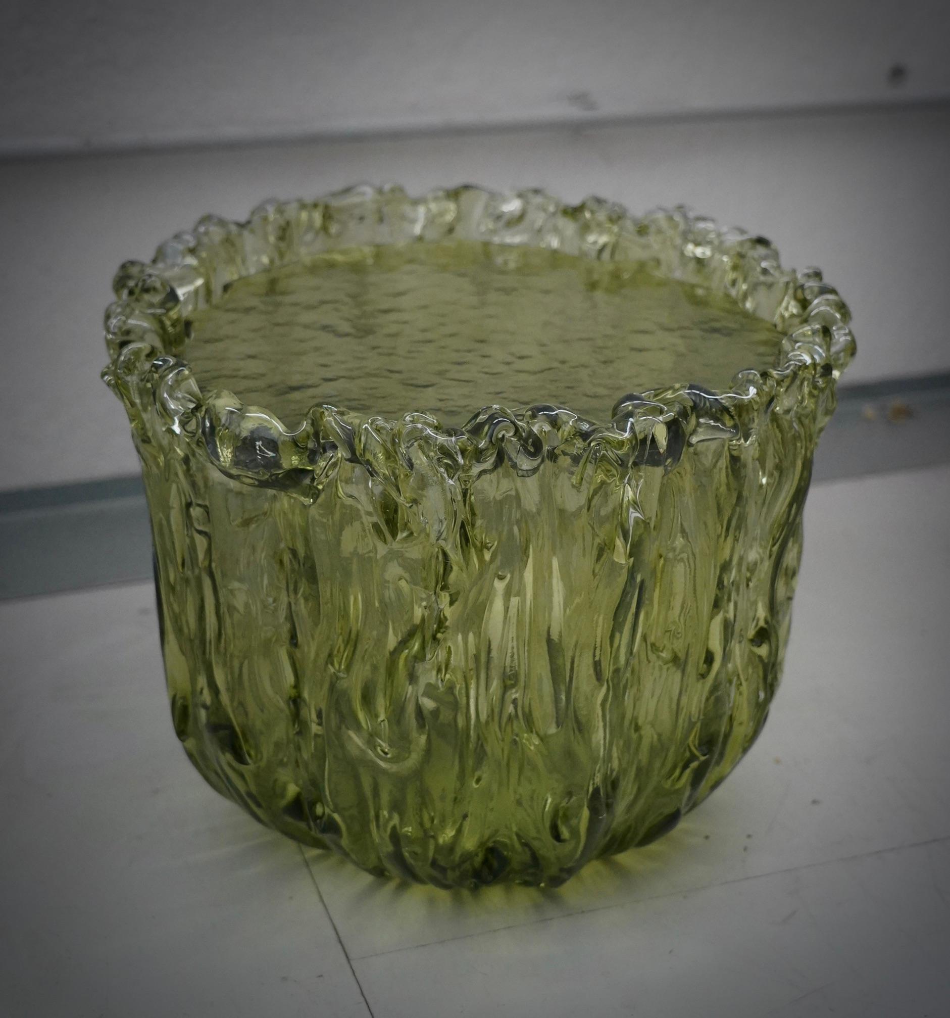 Table basse en verre de Murano très spéciale, dans une nuance de vert passionnante, avec un design très original, une véritable sculpture en verre de Murano.

La table basse est composée d'une grande base en forme de vase en verre de Murano et d'un