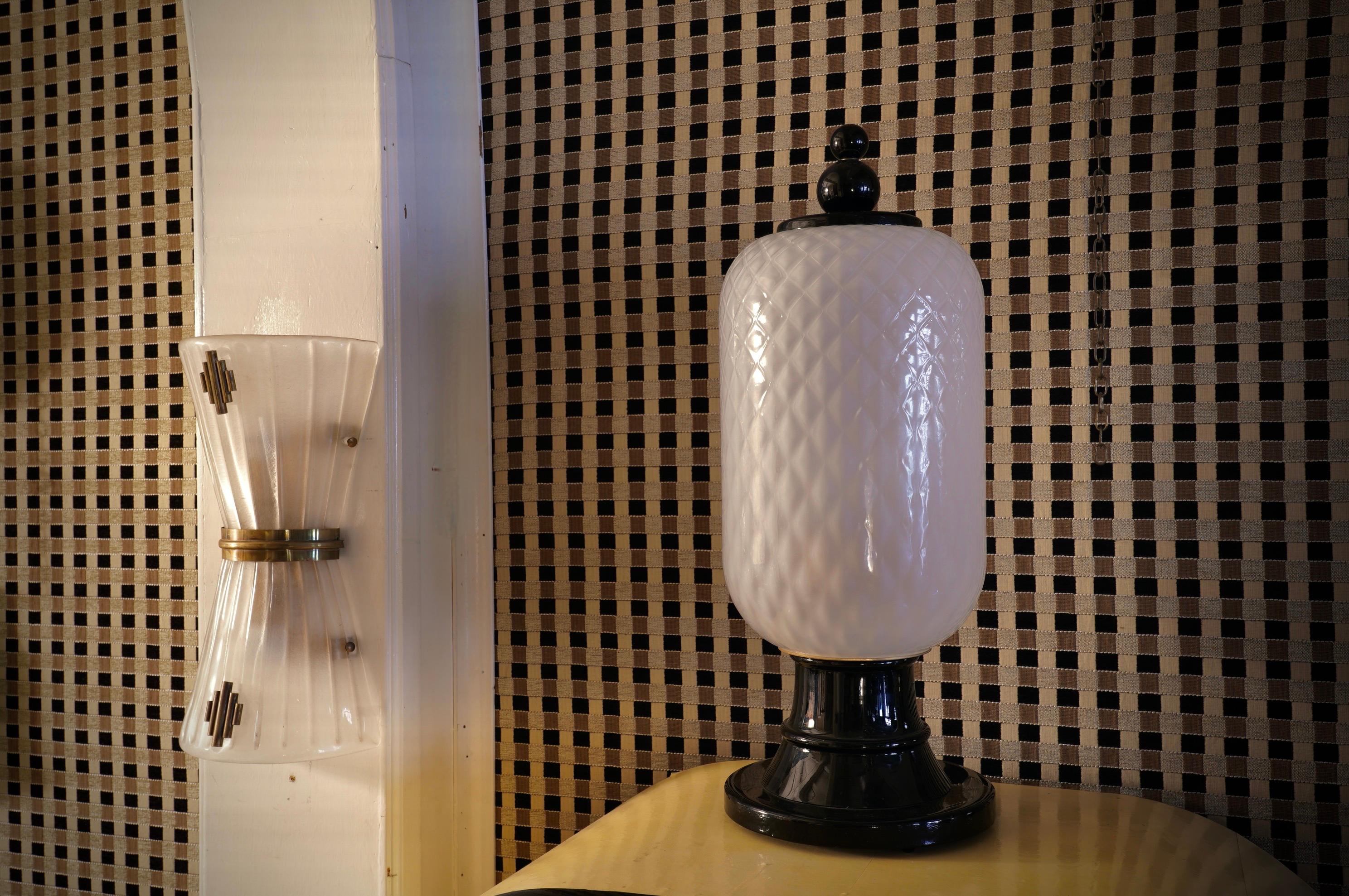 Stunning black and white Murano glass lantern table lamp; The Murano furnaces create an indisputable timeless design, simple but elegant at the same time.

The lamp is made up, starting from the bottom, of a base in black Murano glass with a round