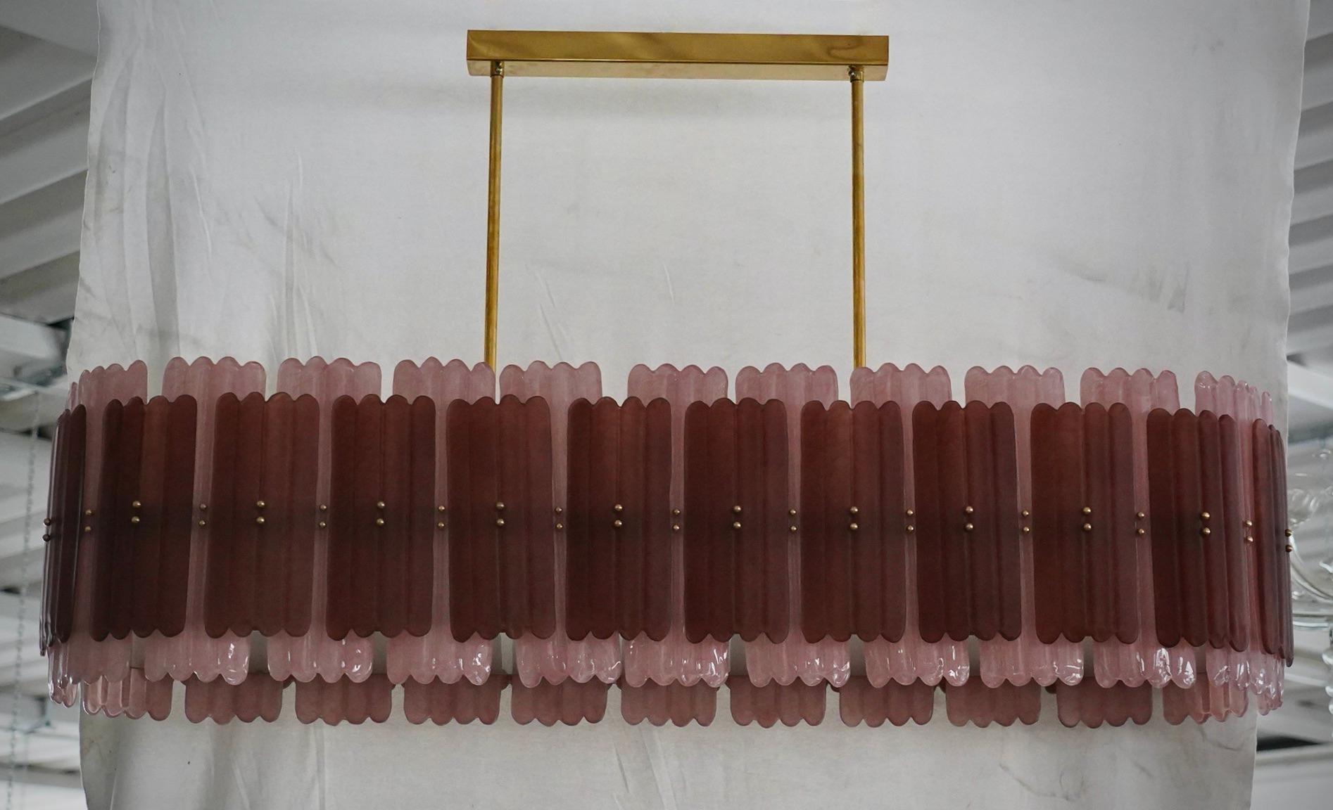 Lustre Murano au design allongé avec une structure en laiton et des verres spéciaux de couleur rose et plus foncée.

Le tout en verre de Murano avec une structure en laiton. Les verres sont traités selon un procédé spécial qui leur confère une