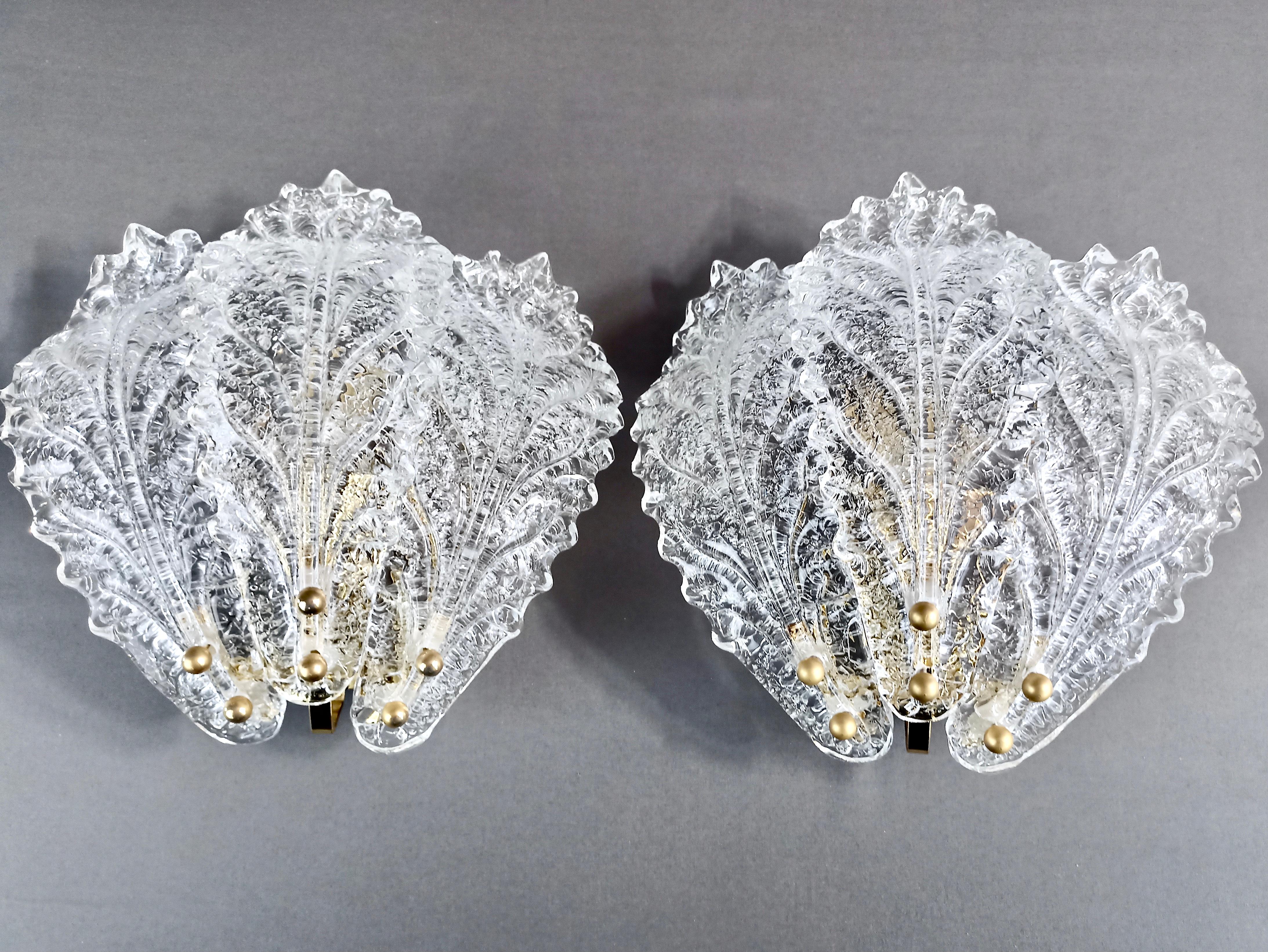 Faszinierendes Paar Murano-Kunstglas-Leuchter aus den 1990er Jahren in der klassischen venezianischen Graniglia-Ausführung. 
Jede Leuchte besteht aus drei blattförmigen Lampenschirmen aus klarem Glas und bietet einen atemberaubenden Lichteffekt, der