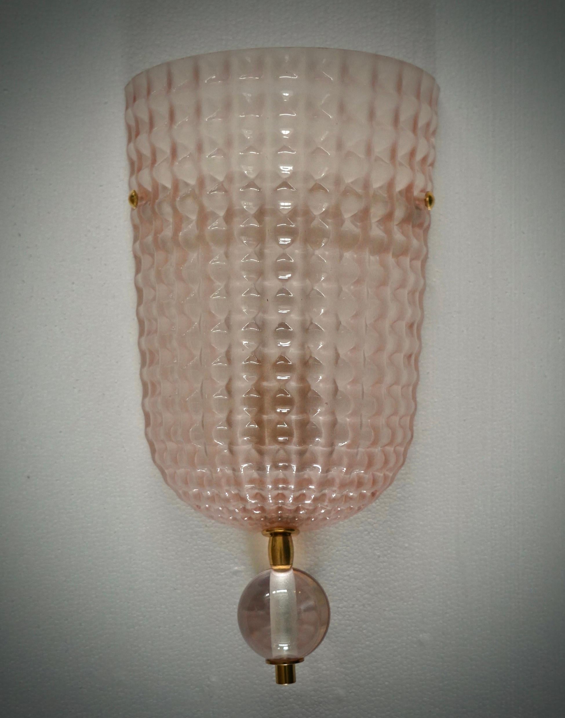 Diseño refinado y delicado para este aplique con cristal de Murano transparente y color rosa. Los hornos de Murano crean un indiscutible diseño atemporal, sencillo pero elegante al mismo tiempo.

El aplique está formado por una estructura metálica