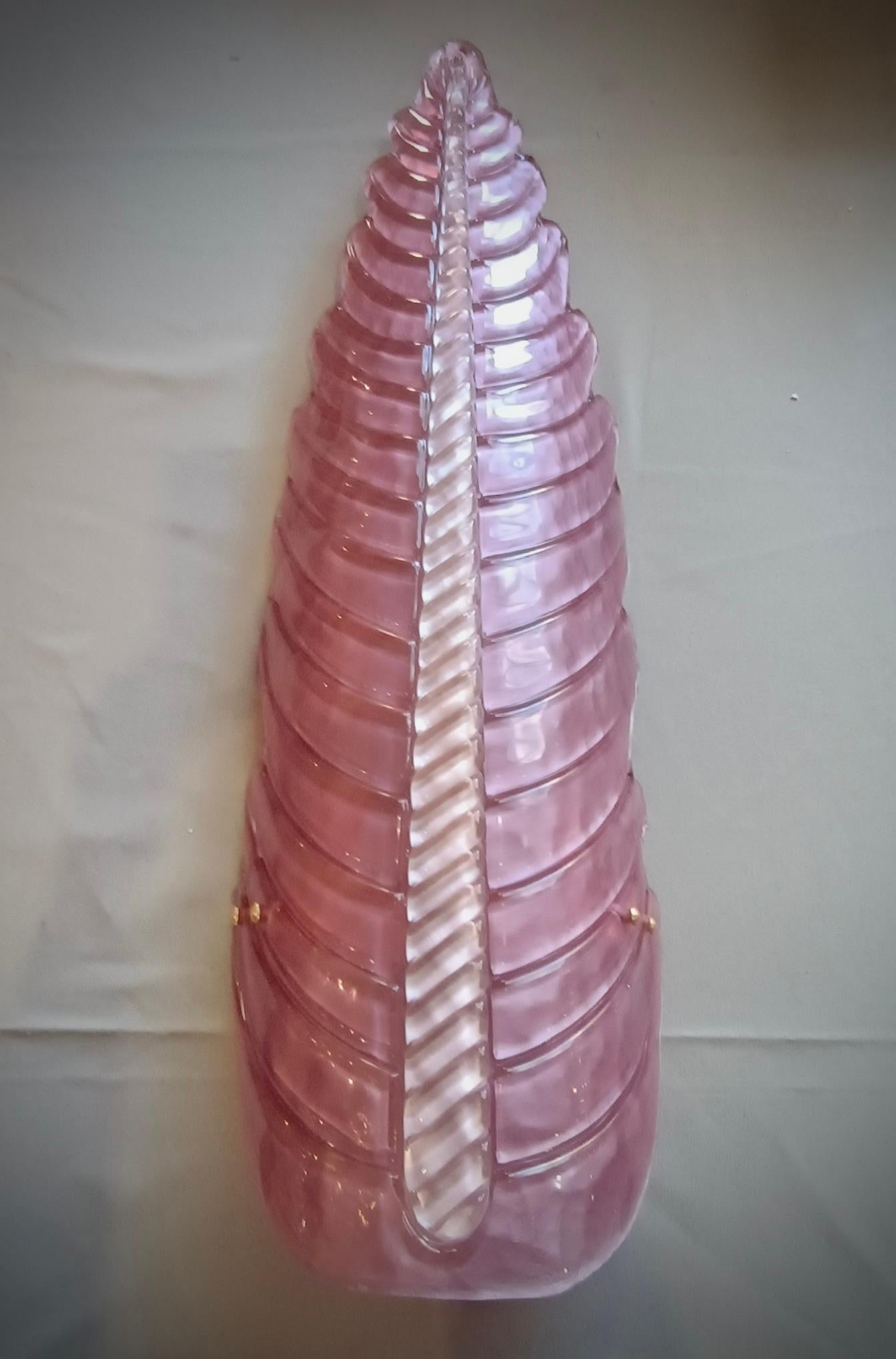 Precioso diseño para este aplique en forma de hoja, todo rosa con un nervio vertical blanco. Refinamiento y clase como en el estilo de Murano, piezas únicas que siempre son preciosas.

El aplique está hecho de una sola pieza de cristal de Murano,