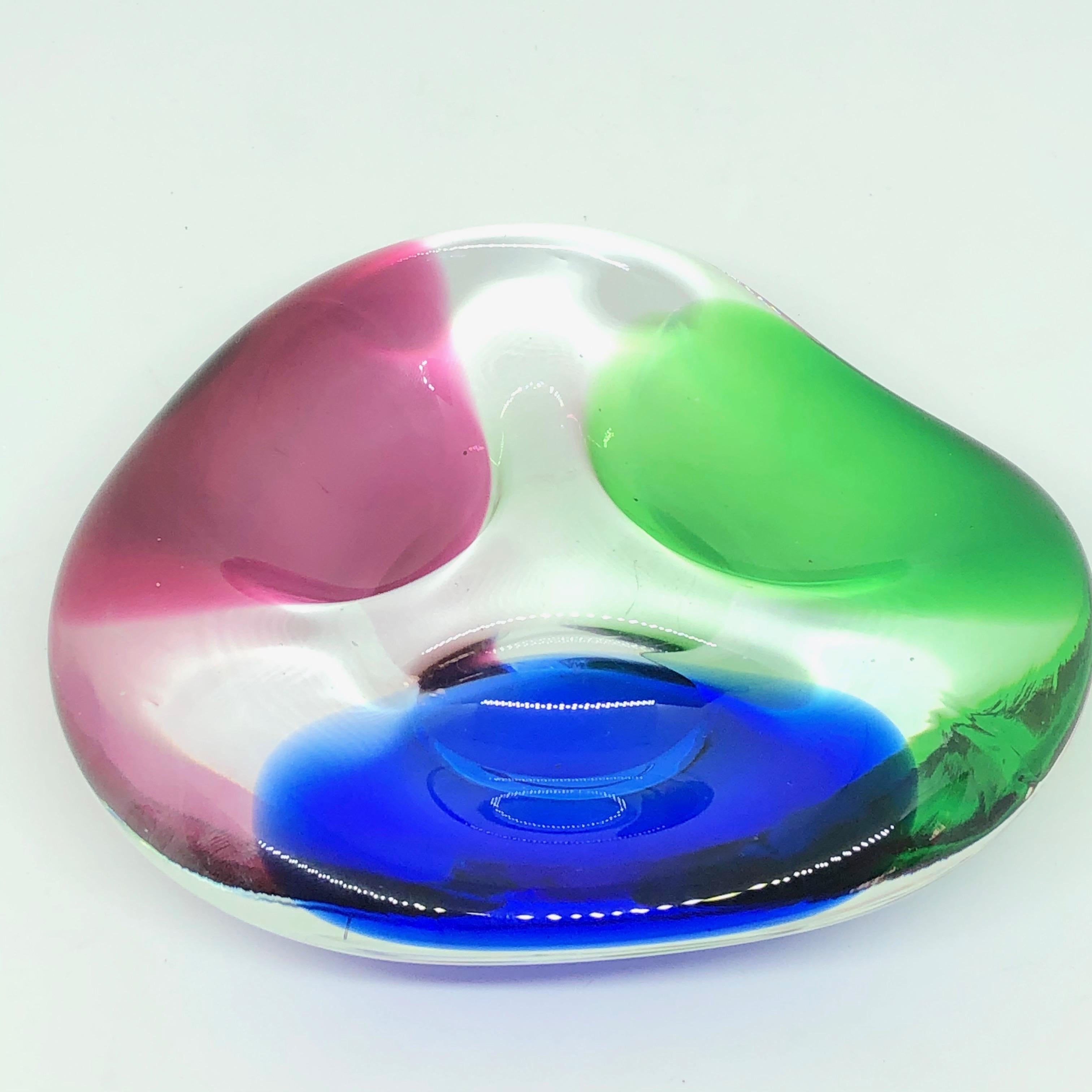 Gorgeous hand blown Murano art glass piece with Sommerso and bullicante techniques. A beautiful organic shaped bowl or catchall in clear glass with blue, red and green colors, Italy, 1980s.