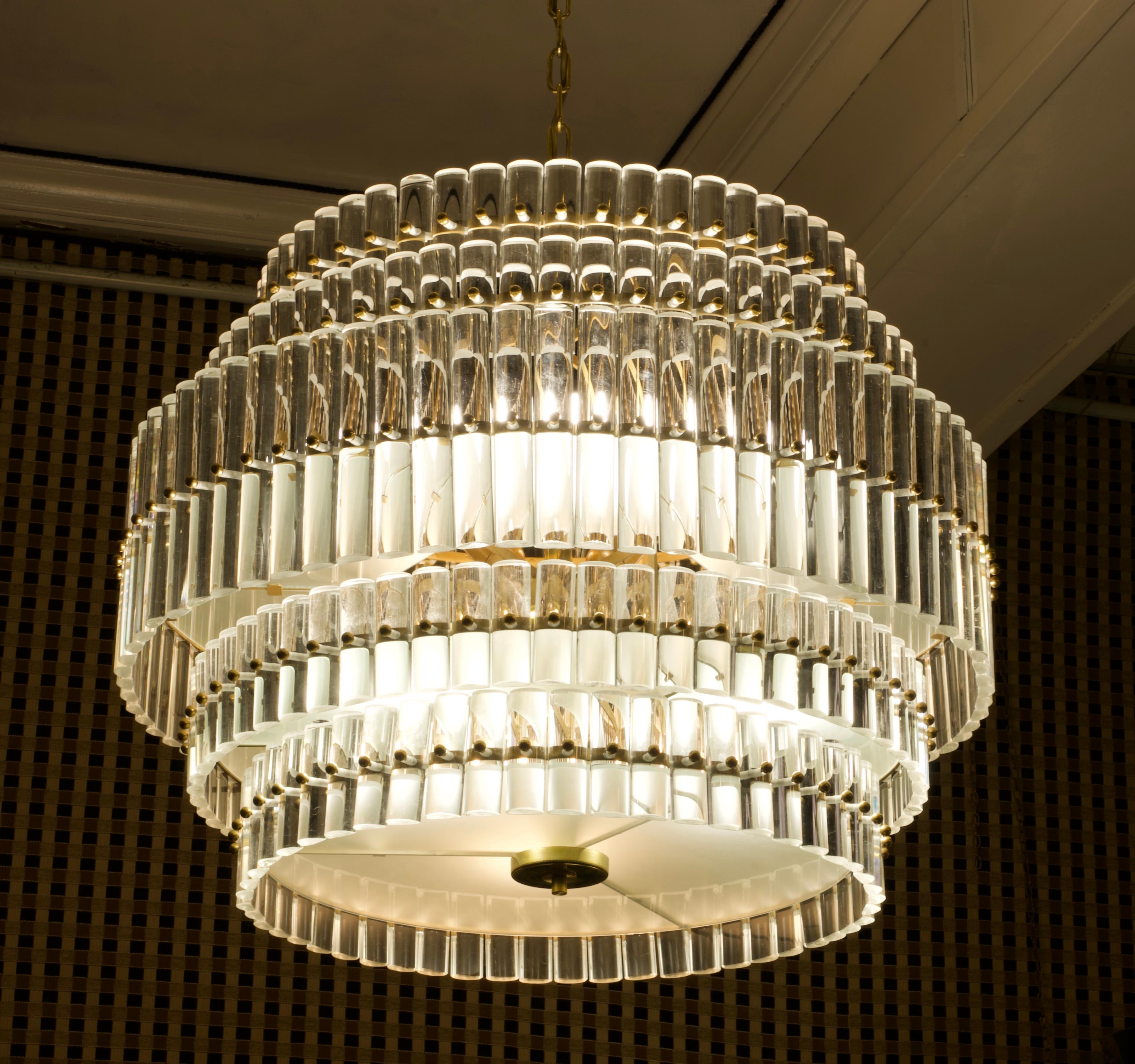 Fantastic round chandelier in Murano glass and polished brass, packed with small rods in half round of glass. The Murano furnaces create an indisputable timeless design, simple but elegant at the same time.

The chandelier is round in shape and