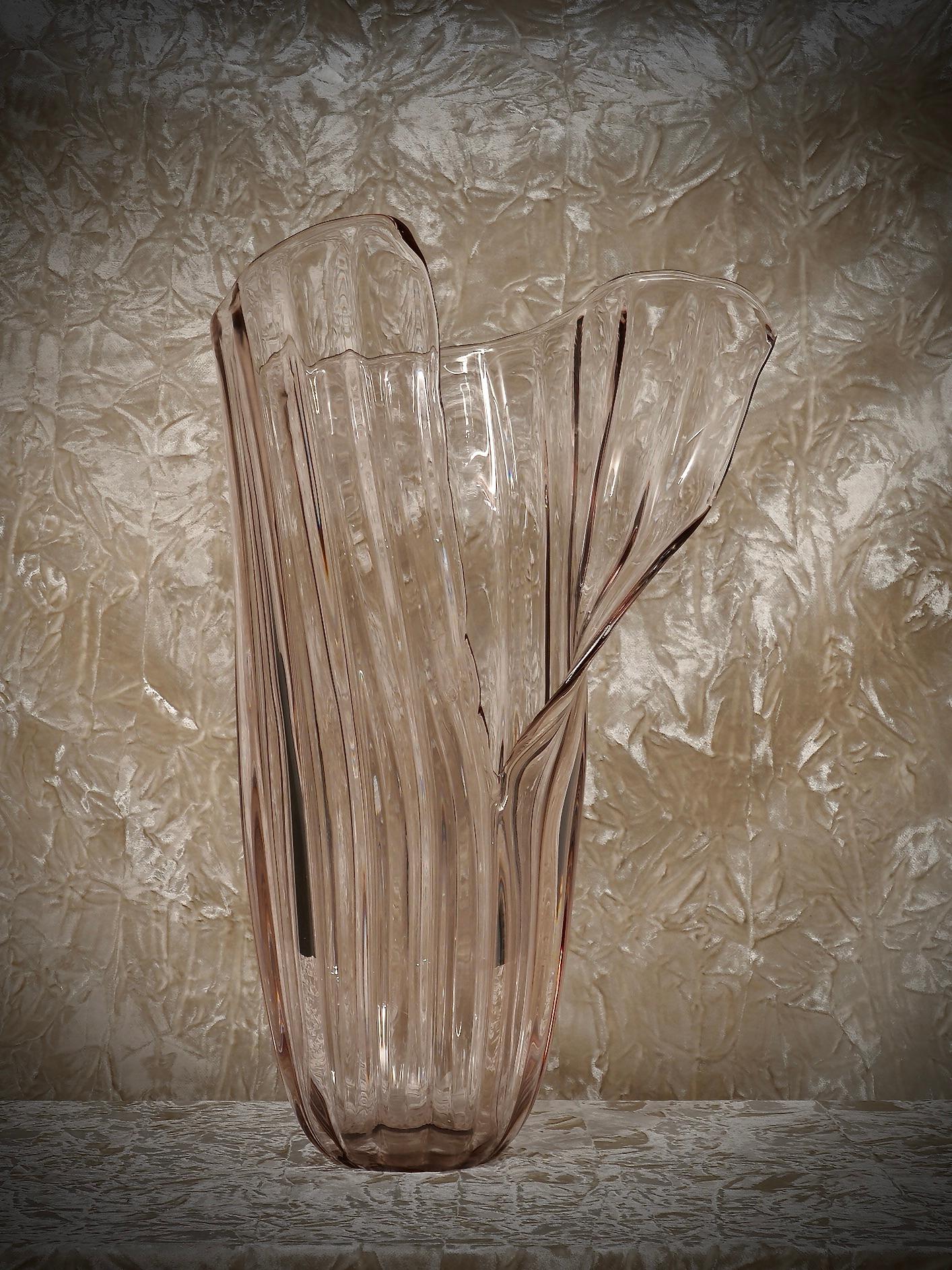 Beautiful vase from the Murano manufacture, particular design open at the front. Light, thin and delicate, it looks like a butterfly has landed on it.

The vase is large in size, and has vertical ribs. The narrow, thick base in the glass contrasts