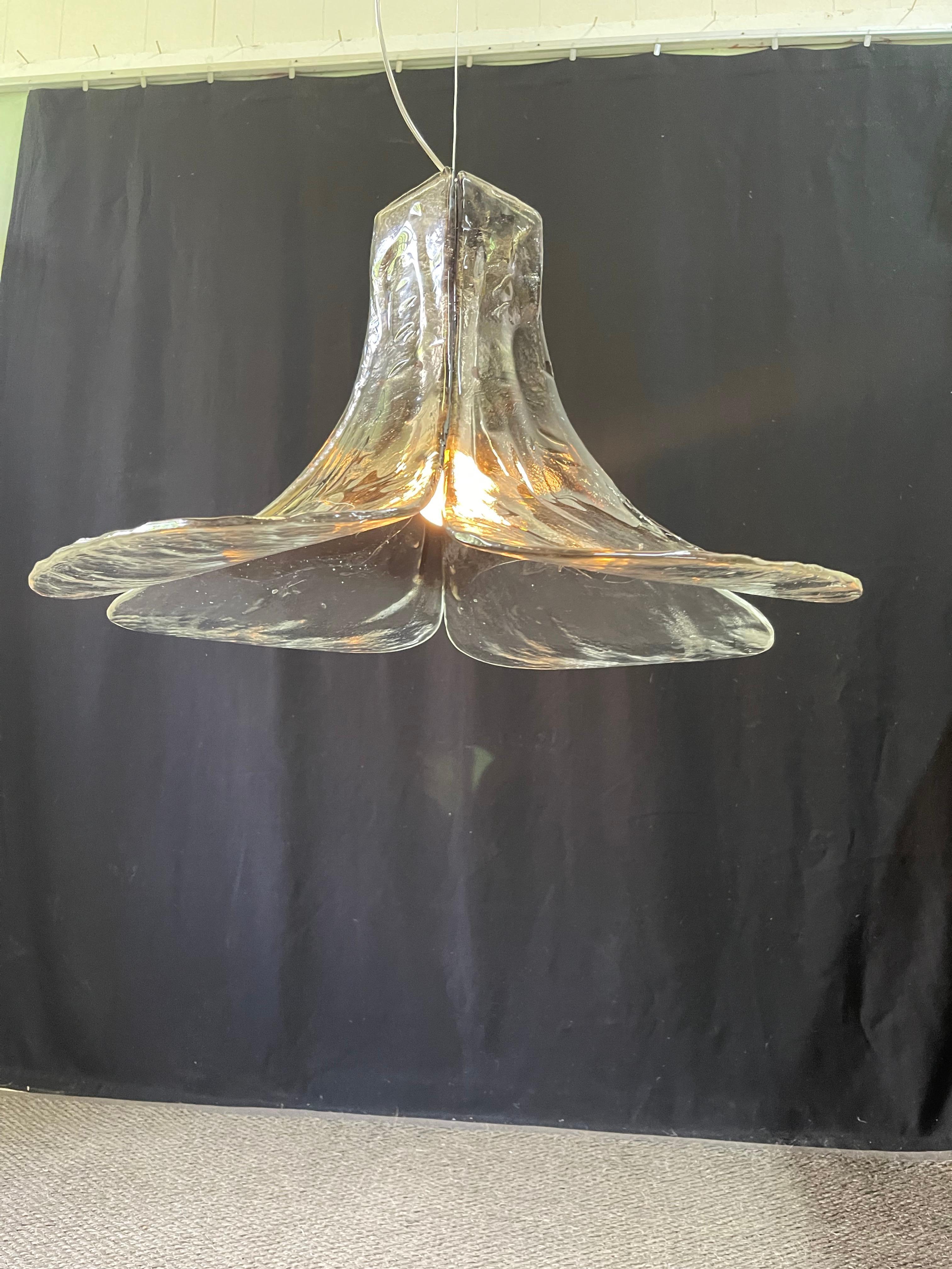 A stylish and exceptional Mid-Century Modern Italian vintage glass chandelier designed by Carlo Nason and manufactured by AV Mazzega. This pendant lamp model LS185 has four very thick, Murano art glass petals (shaded from dark tinted glass to clear