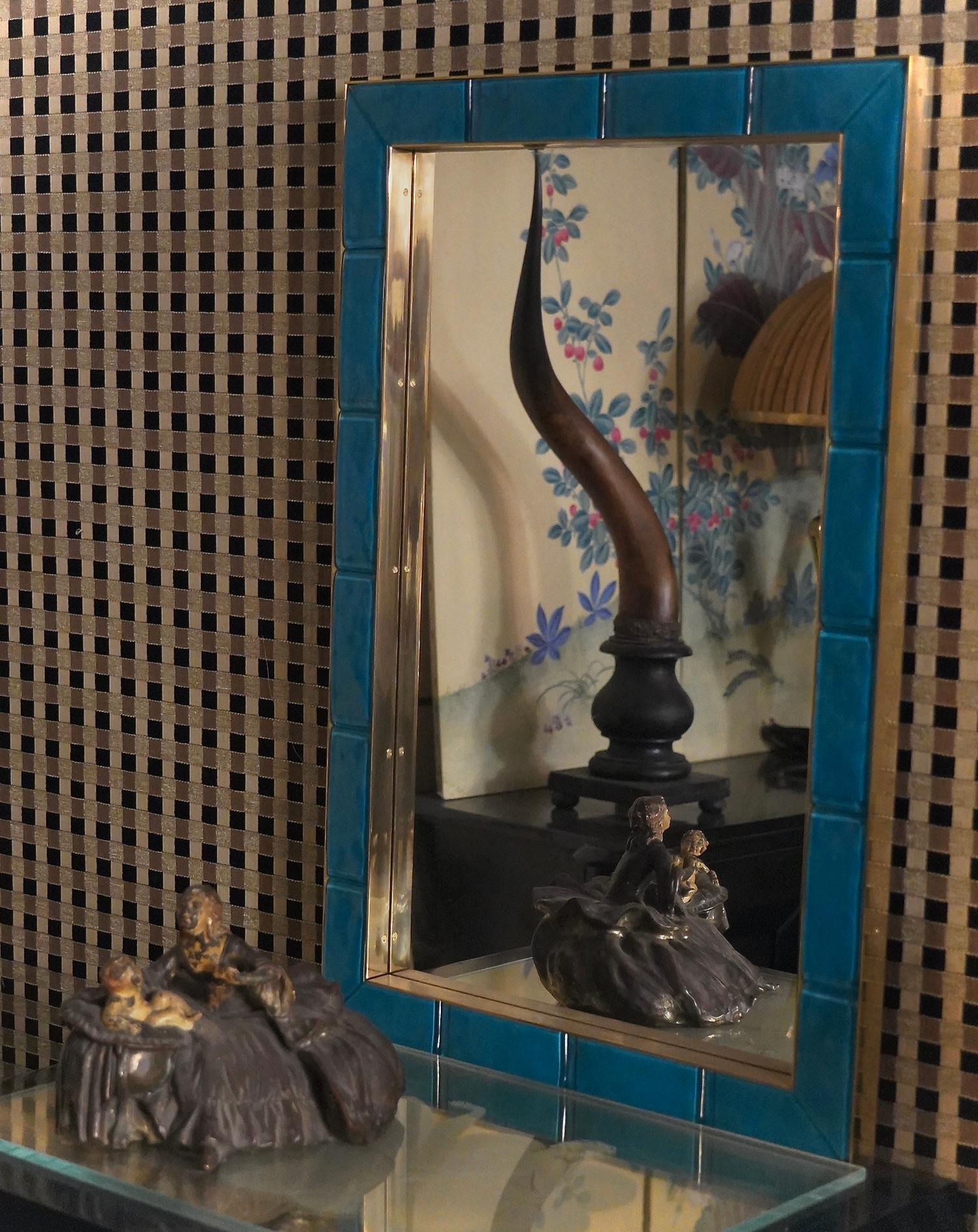 Extraordinary Murano glass frame with a wonderful azure color.

The frame has a wooden rear supporting structure on which particular curved azure colored glass shapes have been applied. A well-polished brass plate runs along the external and