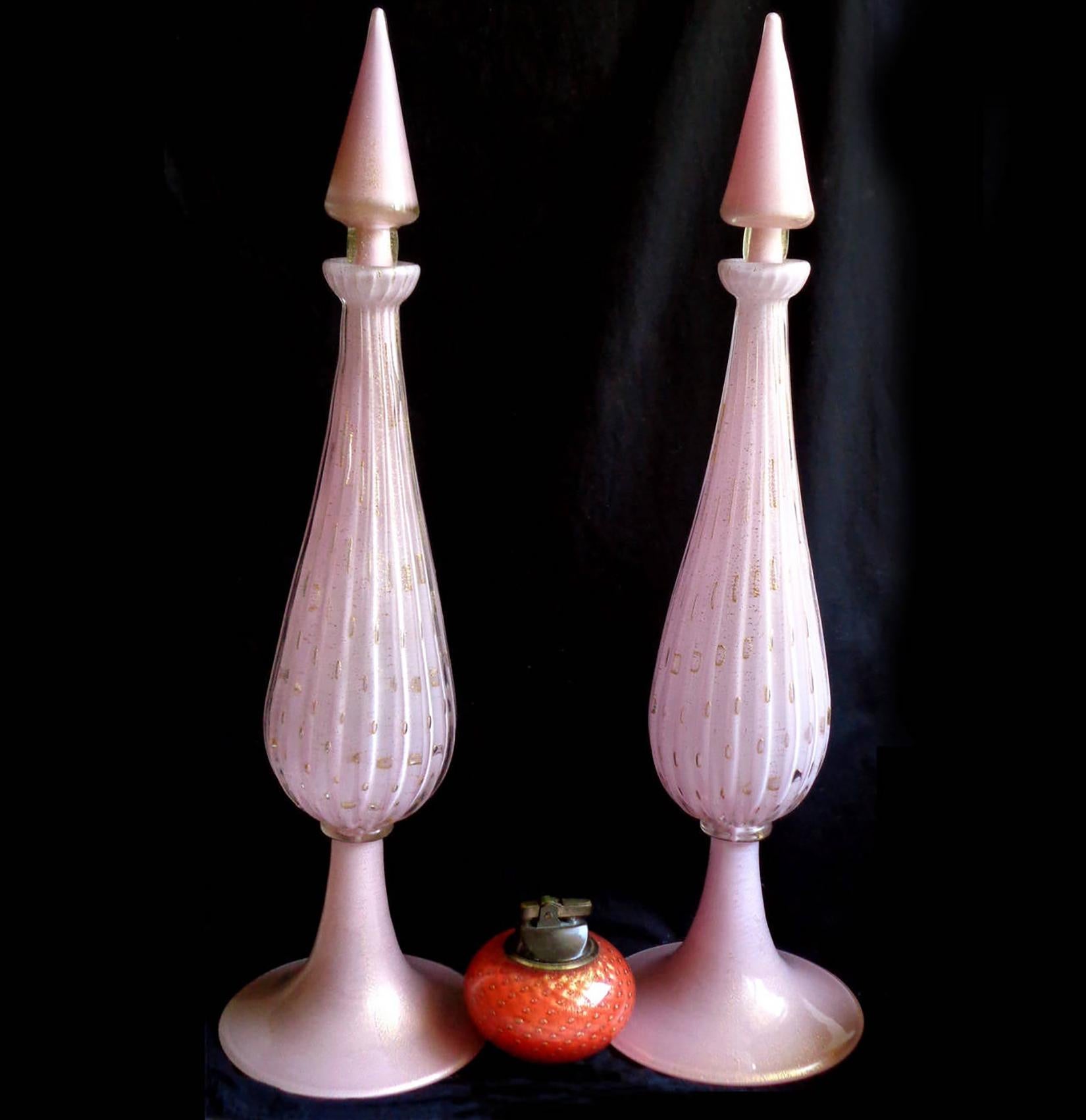 Priced per item (2 decanters available). 
Beautiful and large, vintage Murano hand blown pink, controlled bubbles and gold flecks rocket shaped Italian art glass decanter. Documented to designer Alfredo Barbini, circa 1950s. Each decanter has their