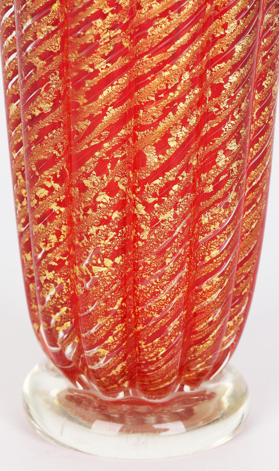 A stunning mid-century Italian Murano red art glass Cordonata D'oro vase with a tri-corn top. The vase is heavily made standing on a clear glass rounded foot with a vertical ribbed design to the body and with a three cornered top with raised edges.