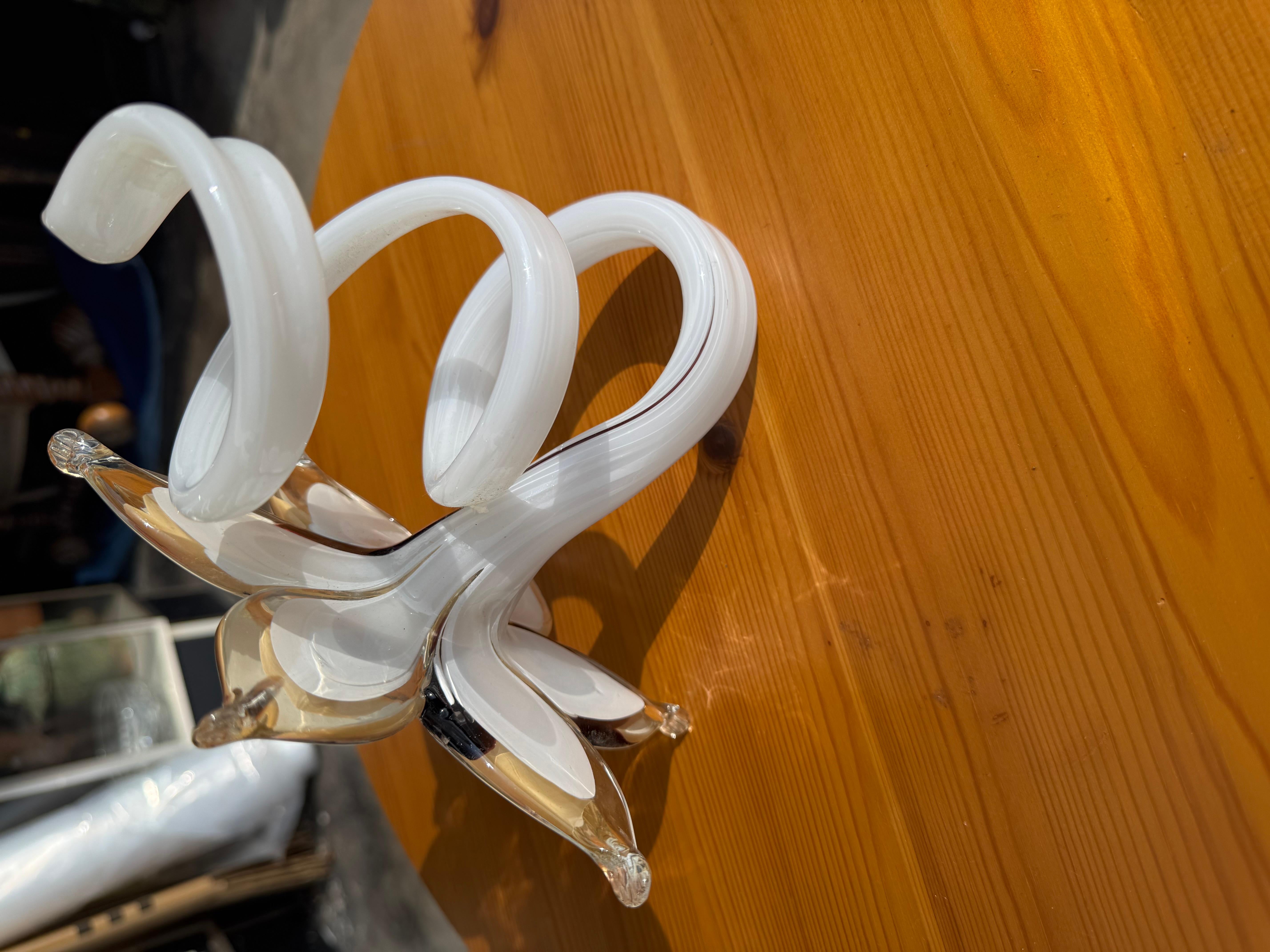 This flower is handblown.
It was crafted in Murano, Italy. 
It is a beige color with brownish accents on three of the petals.
Makes for a great gift.