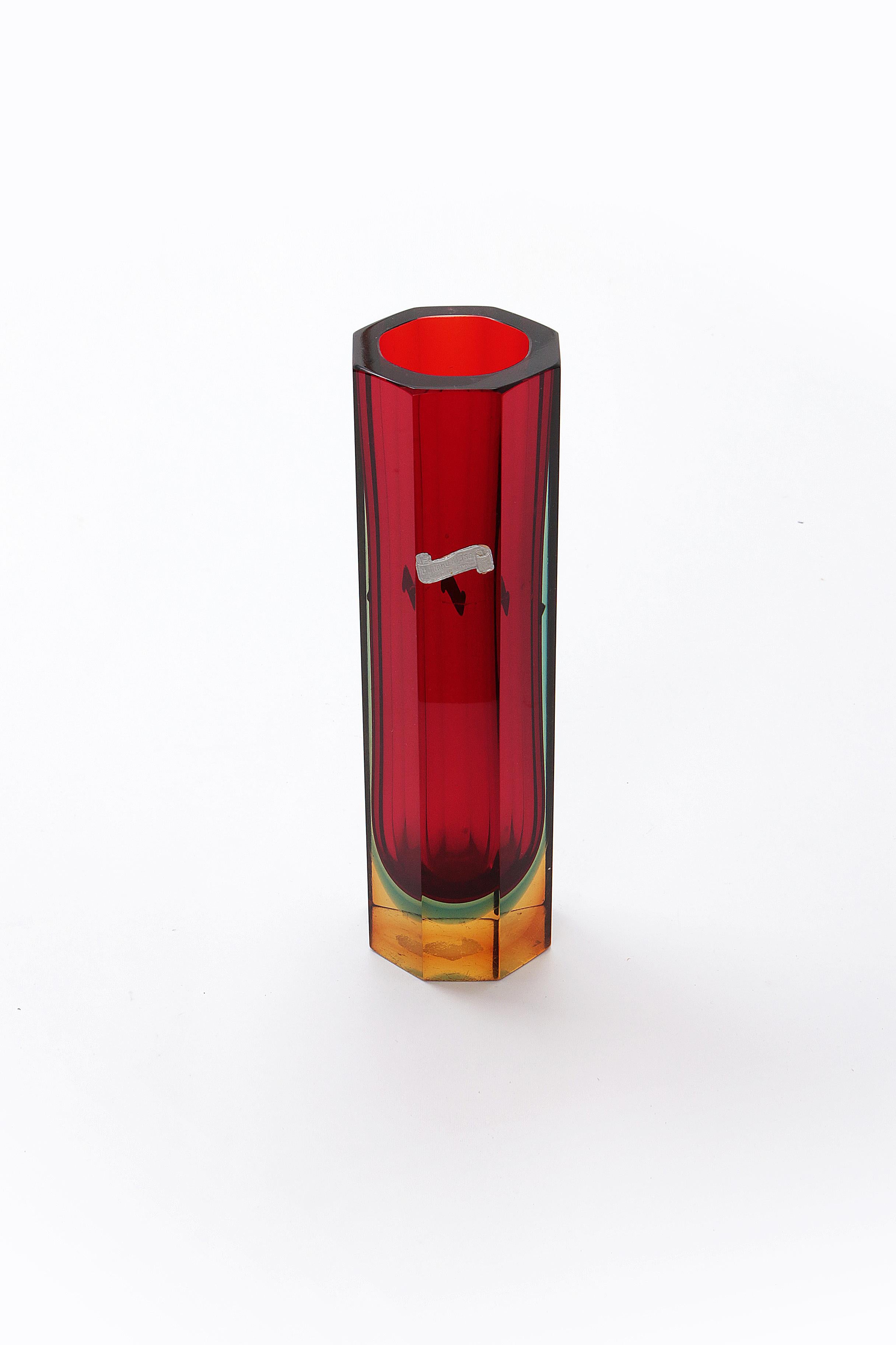 Murano Block Vase 8-seitig, die Farbe ist überwiegend rot mit grün, blau und gelb.

Vintage Design Vase Murano quadratische Blockvase rot/blau, intakt, hergestellt von Kristall/Glas Meister Flavio Poli (1900-1984).

Er war ein italienischer