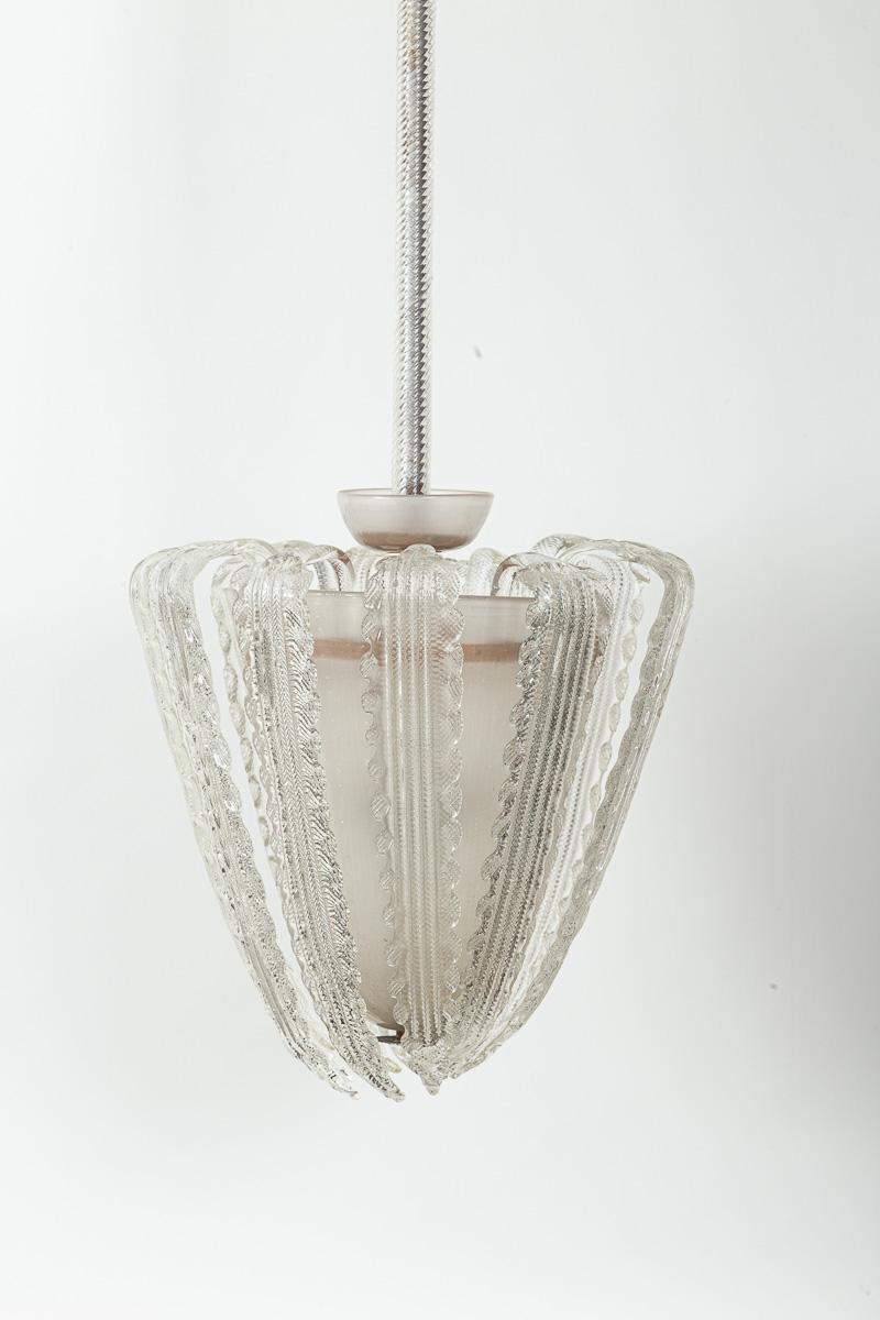 12 preciosos zarcillos soplados transparentes, angulados y arqueados, envuelven su cuerpo cónico soplado blanco, sostenido por su marco original de metal y madera, y cuelgan de un tallo de torchón soplado transparente y un dosel angulado blanco.

Se