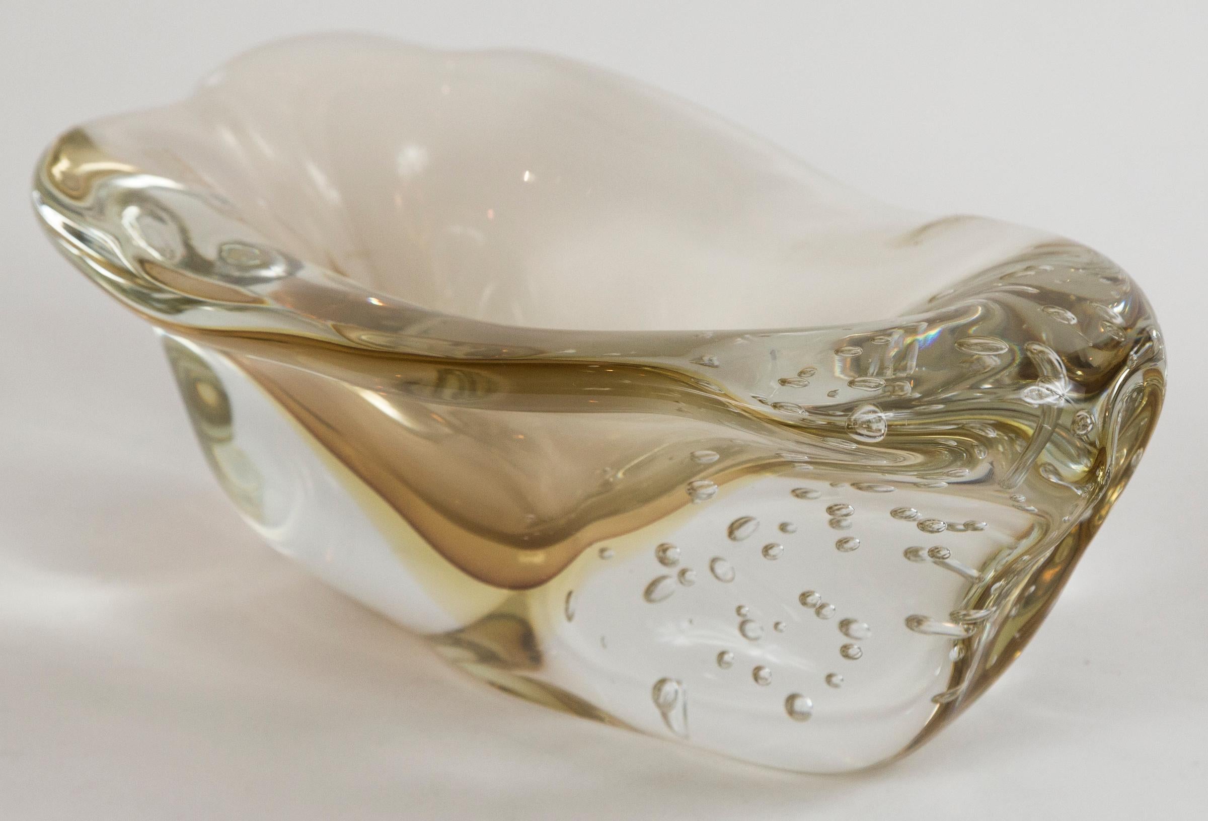 Wonderful one of a kind artisan blown irregular shaped bowl with large controlled bubbles to one side and center floating orb shape in varying layers of citron executed in the sommerso technique, signed by the artist.
Amazing accompaniment to the