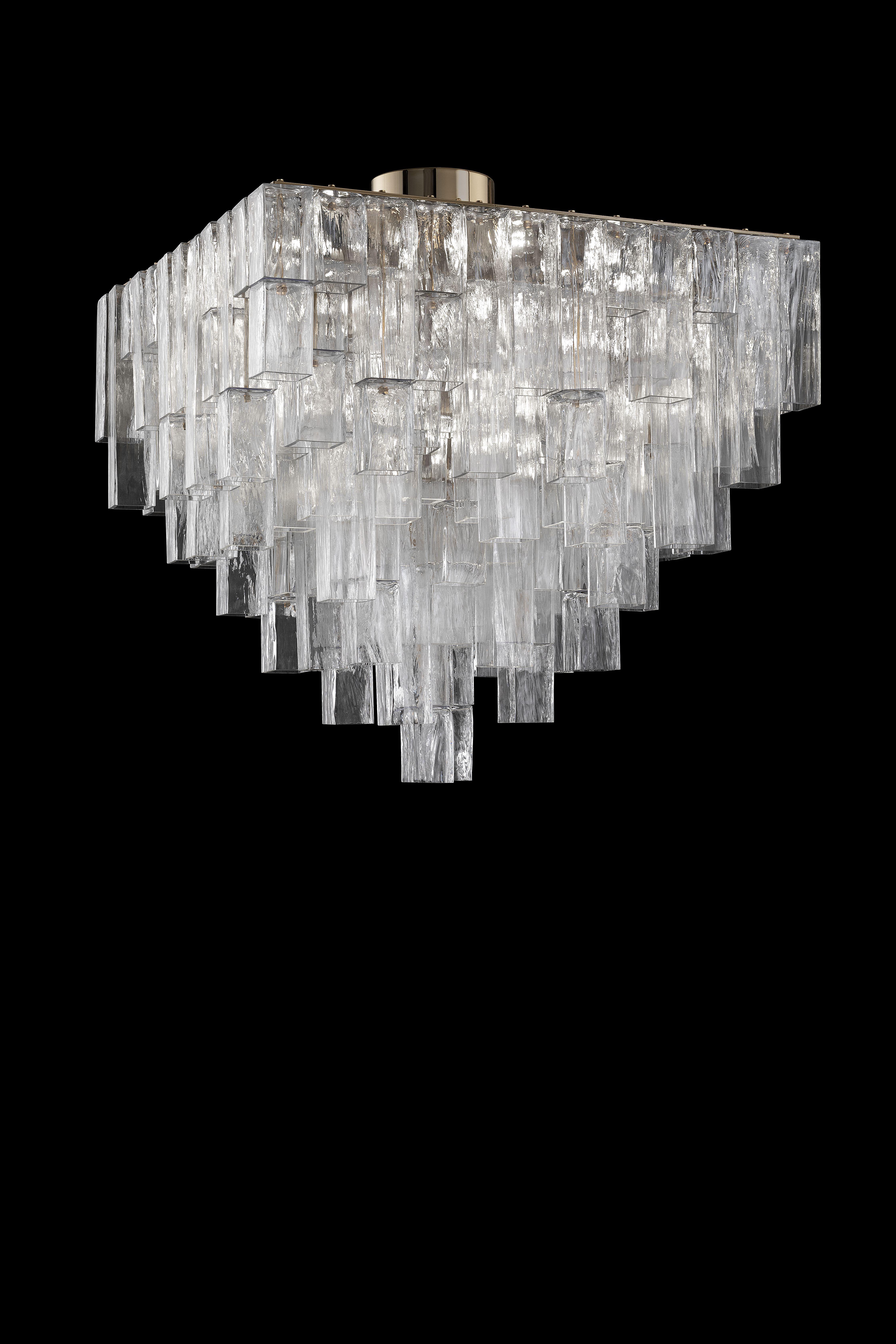 Forti della loro tridimensionalità, questi pezzi interagiscono con l'architettura degli spazi, definendo volumi e confini. La struttura delle lampade è completamente nascosta, mentre i tubi a sezione quadrata scendono dal soffitto. Le composizioni