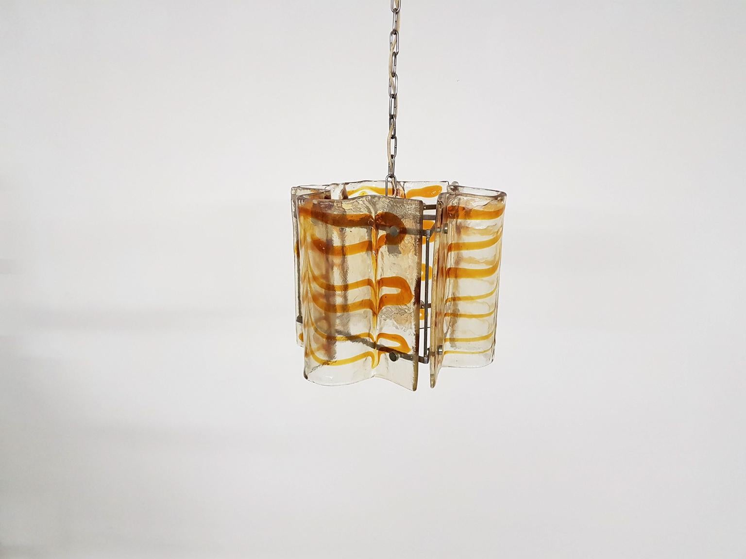 Heavy hand blown glass chandelier. Designed and made in Italy in the 1960s.

This chandelier is made of beautiful curved hand blown Murano glass with a brown or orange color melted inside. These colored 