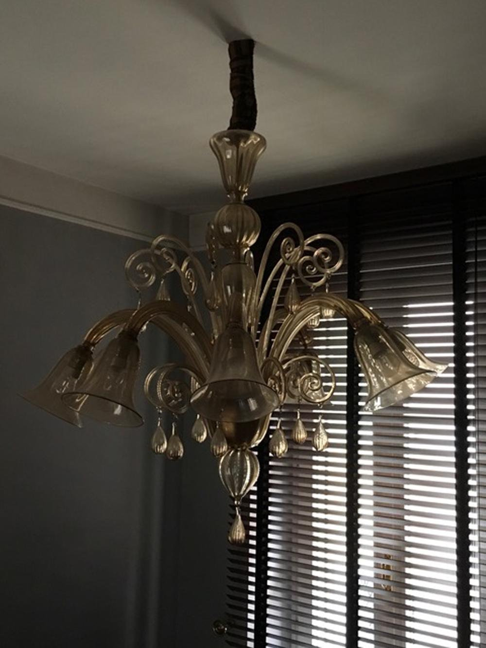 This elegant  blown Murano glass chandelier has 8 arms, 8 lights and 8 decorative arms.
The bulbholder has a delicate flower form and the color is a fine light gold.
It is a piece of timeless beauty and a contemporary presence in the room.

With