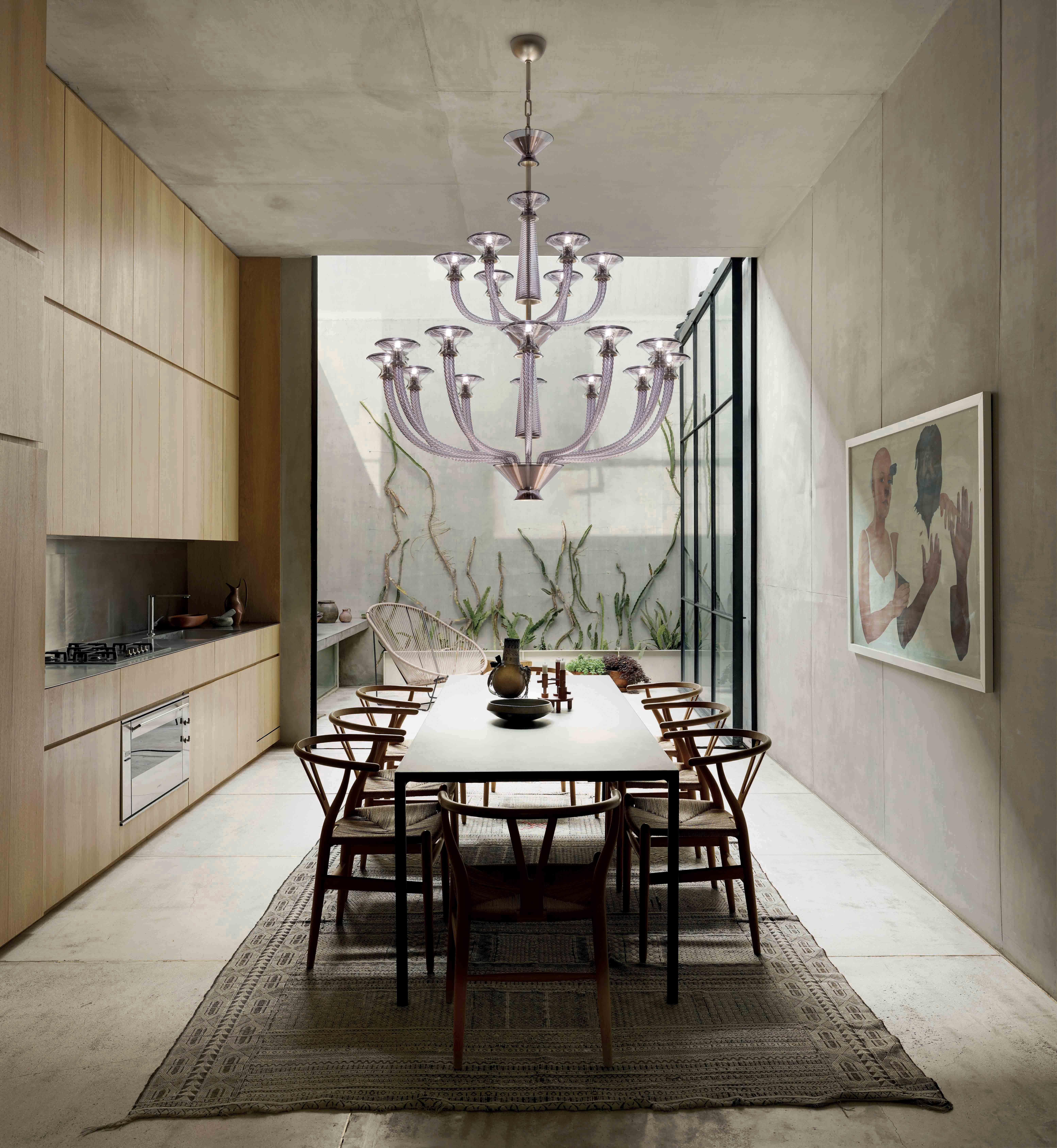 Vertigo is a family of chandeliers and wall sconces that thrives on contrasts, combining dynamism and symmetry, delicacy and power. Its original vertical thrust is attenuated by the radial extension of the arms, softly opening like petals. The main