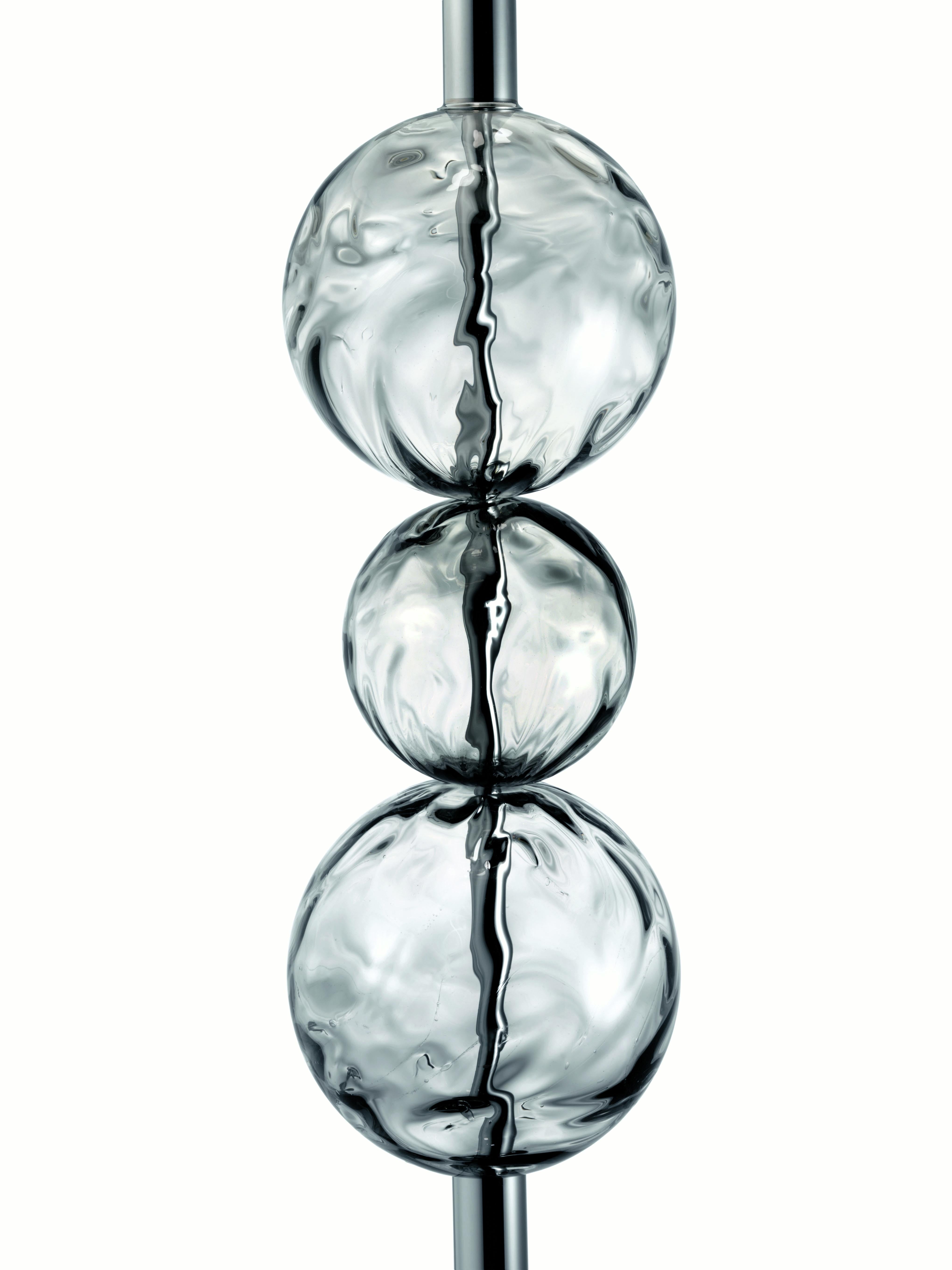 Lámpara de pie con un vástago muy esbelto que lleva alineadas esferas de cristal veneciano trabajadas con la técnica tradicional de la 