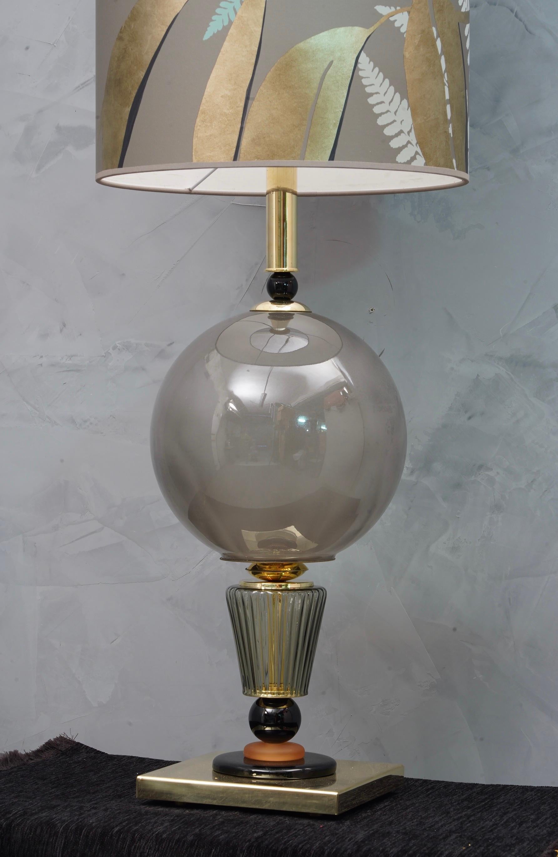 Incredible beauty for a pair of Murano glass table lamps from the middle of the century. 

All in Murano blown glass, black and amber color. Formed by a large central sphere in amber color and a square base in brass, between the two are inserted