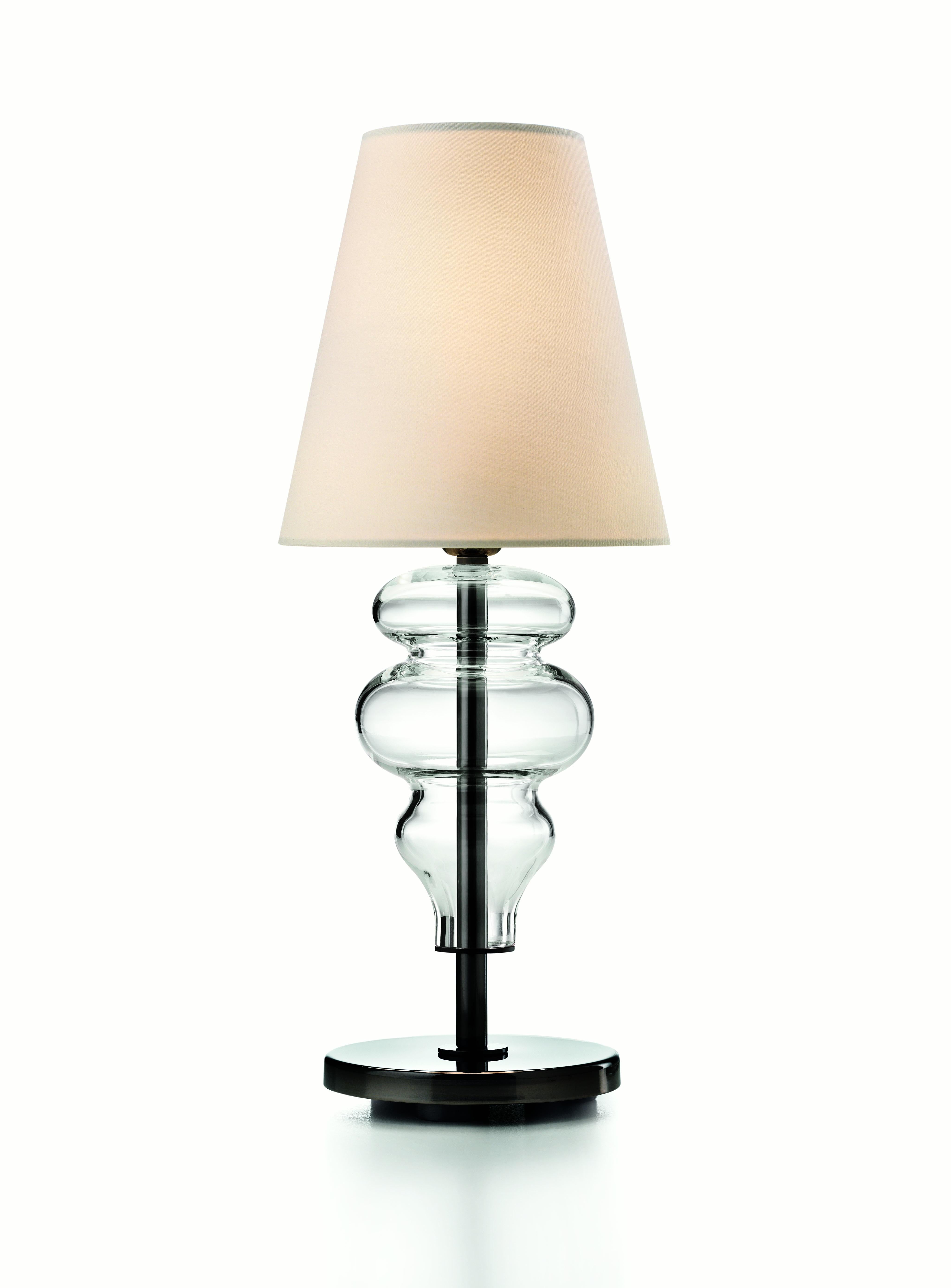Transparency and lightness. Thanks to the mouth blown ogives aligned in series this tiny table lamp appears extremely slight and delicate. 
