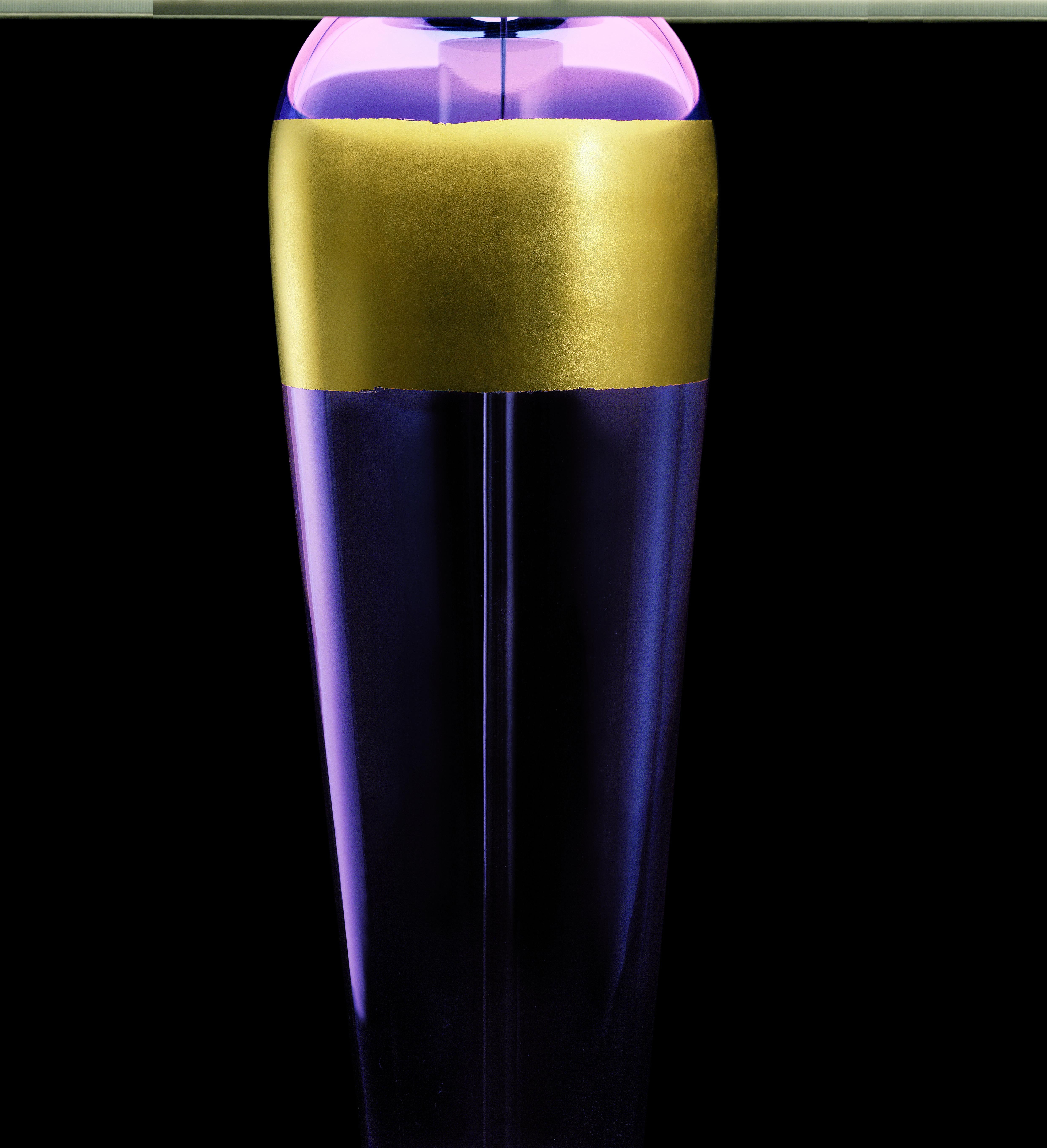Sinuous and curvy lines for this table lamp whose precious detail is the 24K gold leaf strip applied on the surface.
