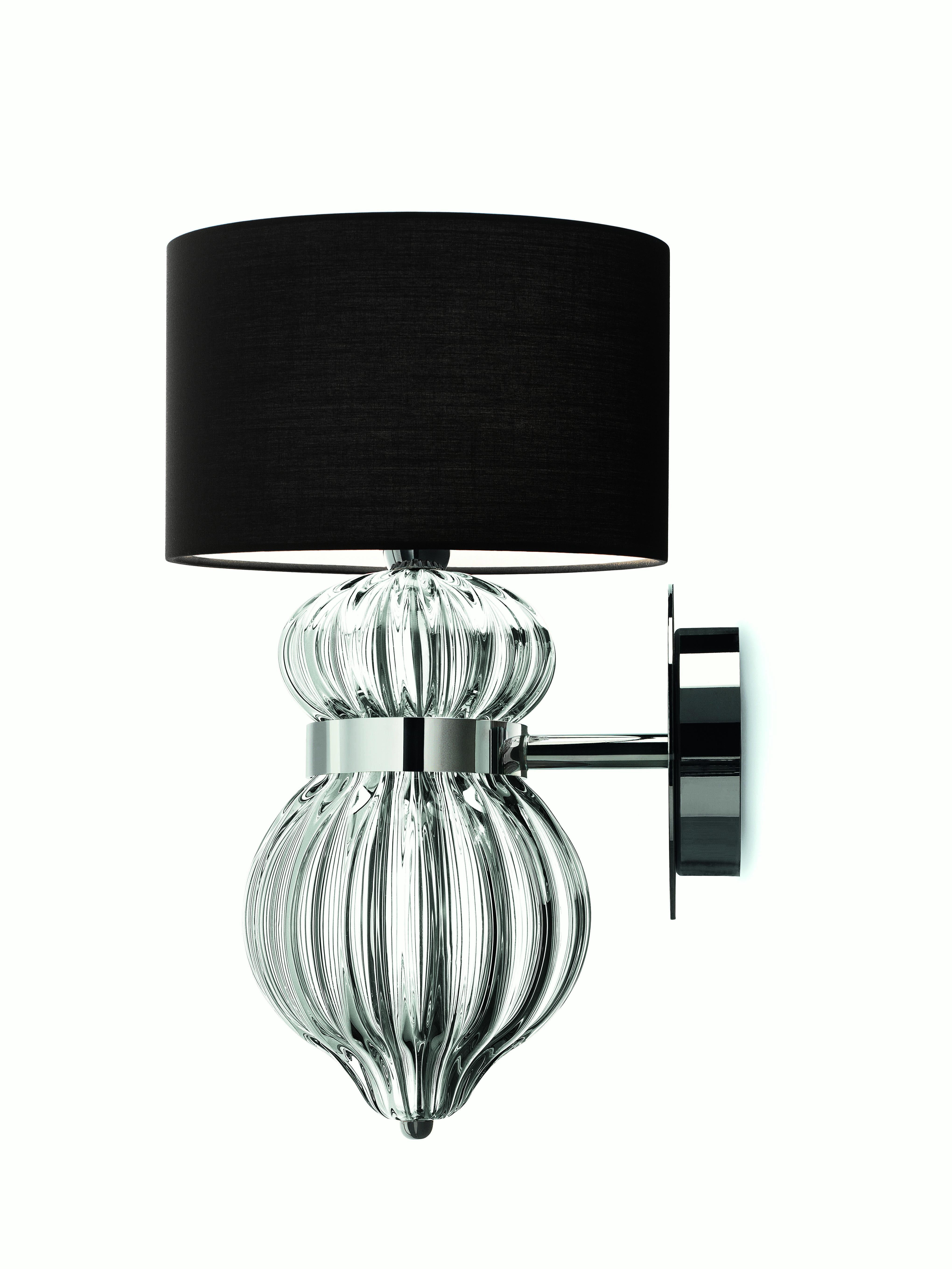 A shapely wall sconce with generous dimensions whose design recalls somehow Botero’s drawings. The metal neck and the oversize shade are distinctive of this object.
