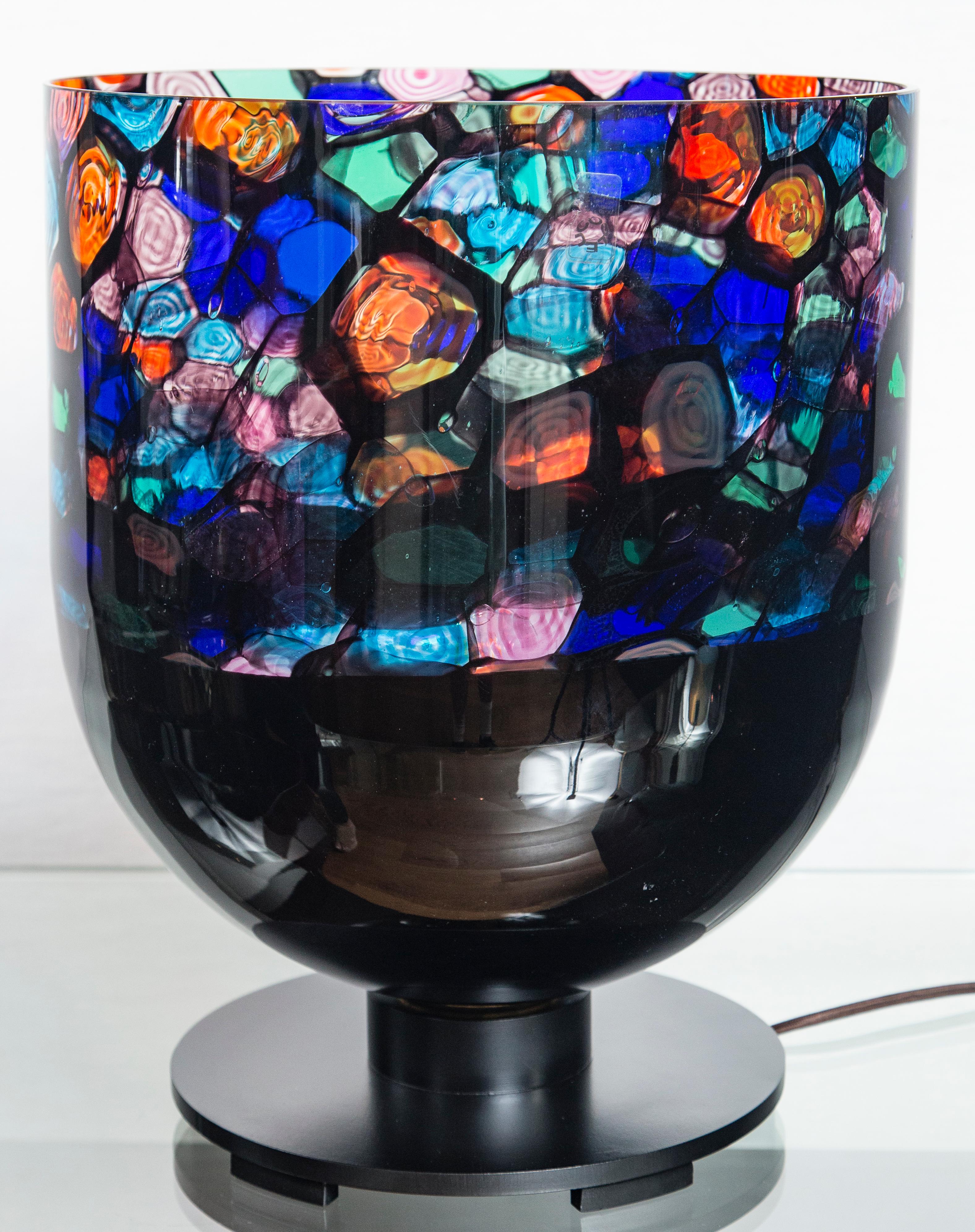 Murano blown Murrine table lamp by Noti Massari for Leucos
Beautiful multi-color patterns and swirls are reflected more brightly with interior base in white glass while the exterior bottom portion of the base remains black blending with its black