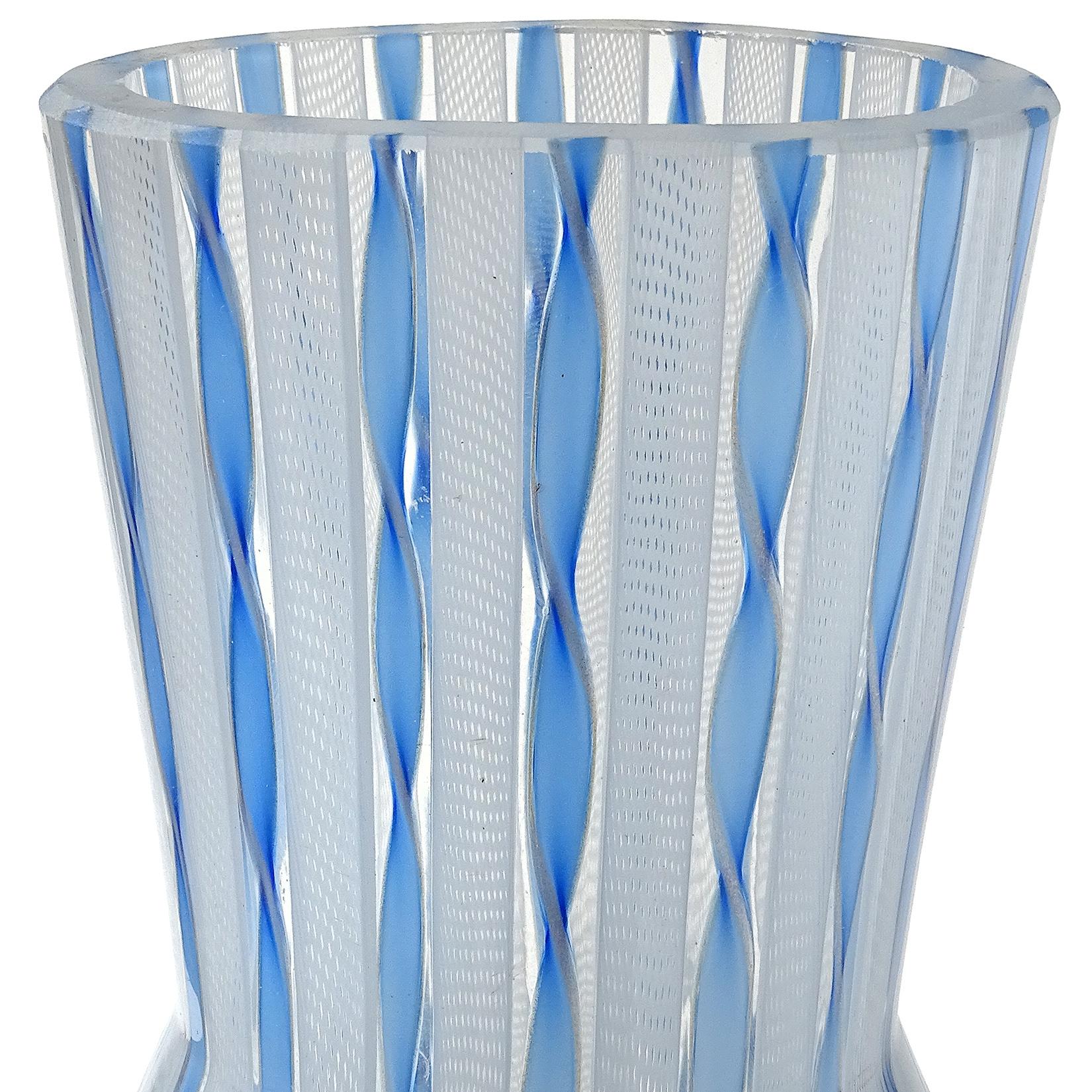 Beautiful Murano hand blown blue and white ribbons Italian art glass flower vase. It has twisting blue and copper aventurine ribbons, alternating with white Zanfirico net ribbons. The mouth is an oval shape, which is unusual on a circular vase.