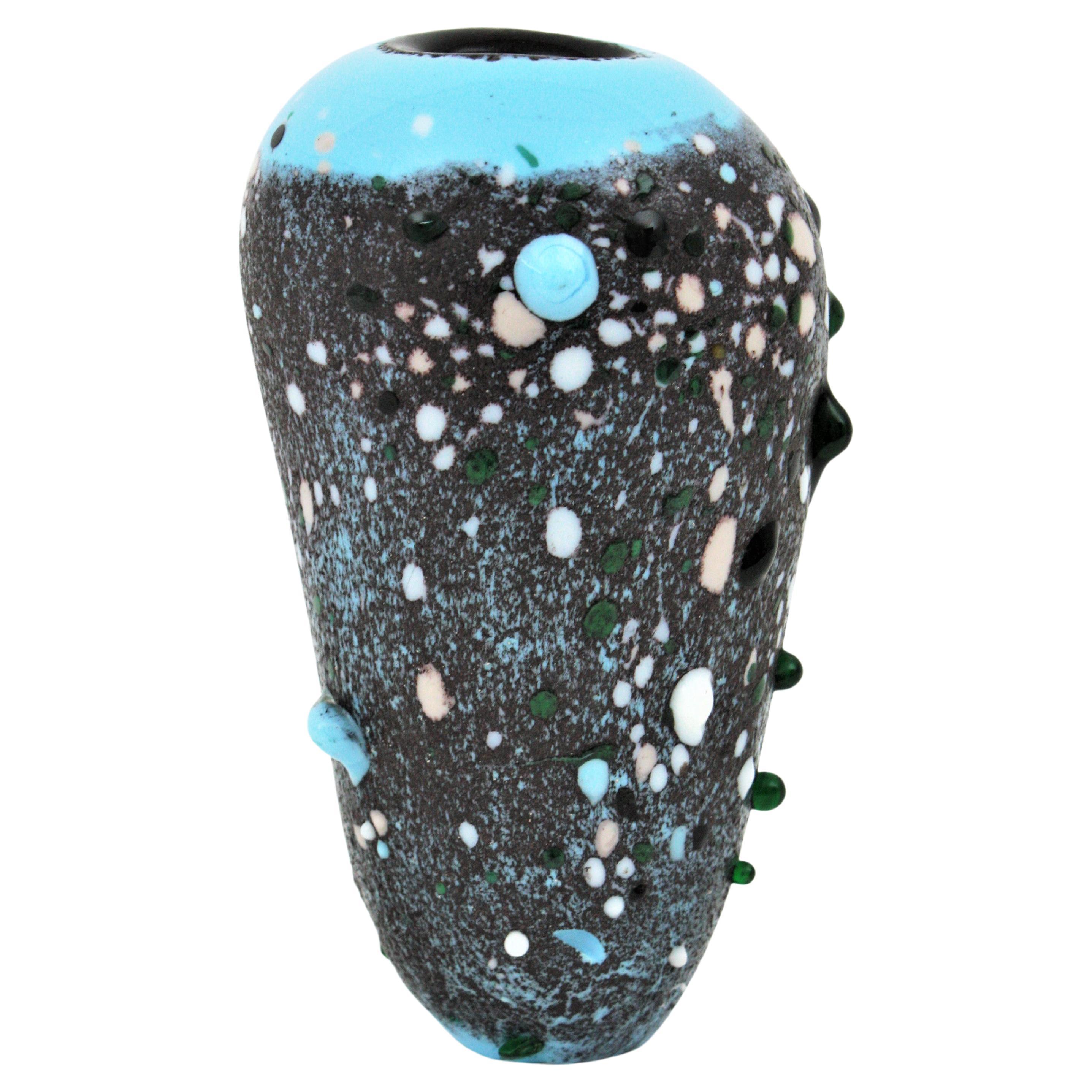 Handblown Murano art glass ovoid vase with murrina applied glass drops. Italy, 1950s.
This eye-catching Murano vase has an interior part in black glass covered by a layer in soft blue and gray glass. The beauty of this vase is highlighted by