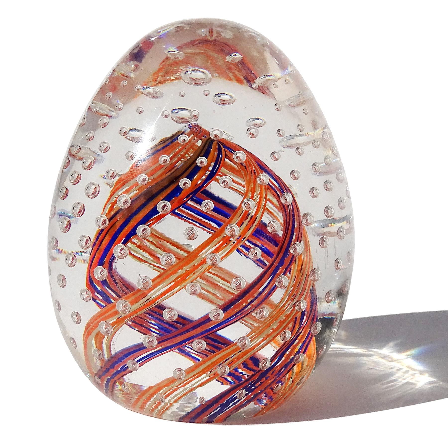 Beautiful and colorful vintage Murano hand blown blue, orange, white and bubbles Italian art glass egg shaped paperweight. Created in the manner of the Fratelli Toso company. This paperweight has orange and cobalt blue, and orange and white twisting