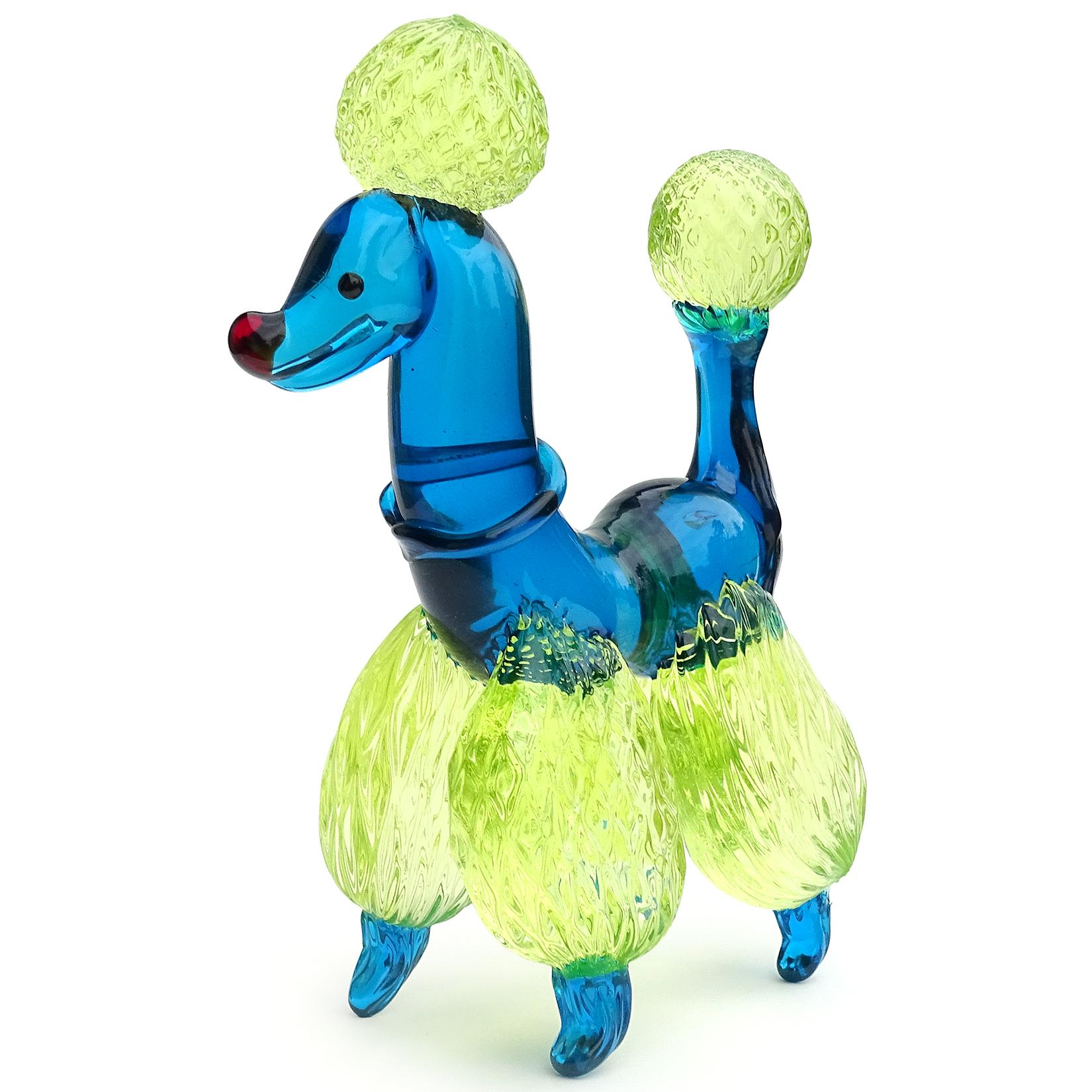 Beautiful vintage Murano hand blown cobalt blue and yellow Italian art glass poodle puppy dog sculpture. It has a quilted pom-pom design on the legs, tails and puff on its head. Blue collar on his neck, red eyes and nose. The fur glows under a black